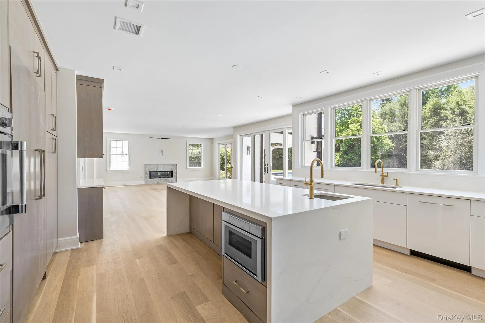 A generous center island with seating anchors the kitchen, while expansive windows bathe the space in natural light from morning through evening. A generous center island with seating anchors the kitchen, while expansive windows bathe the space in natural light from morning through evening.