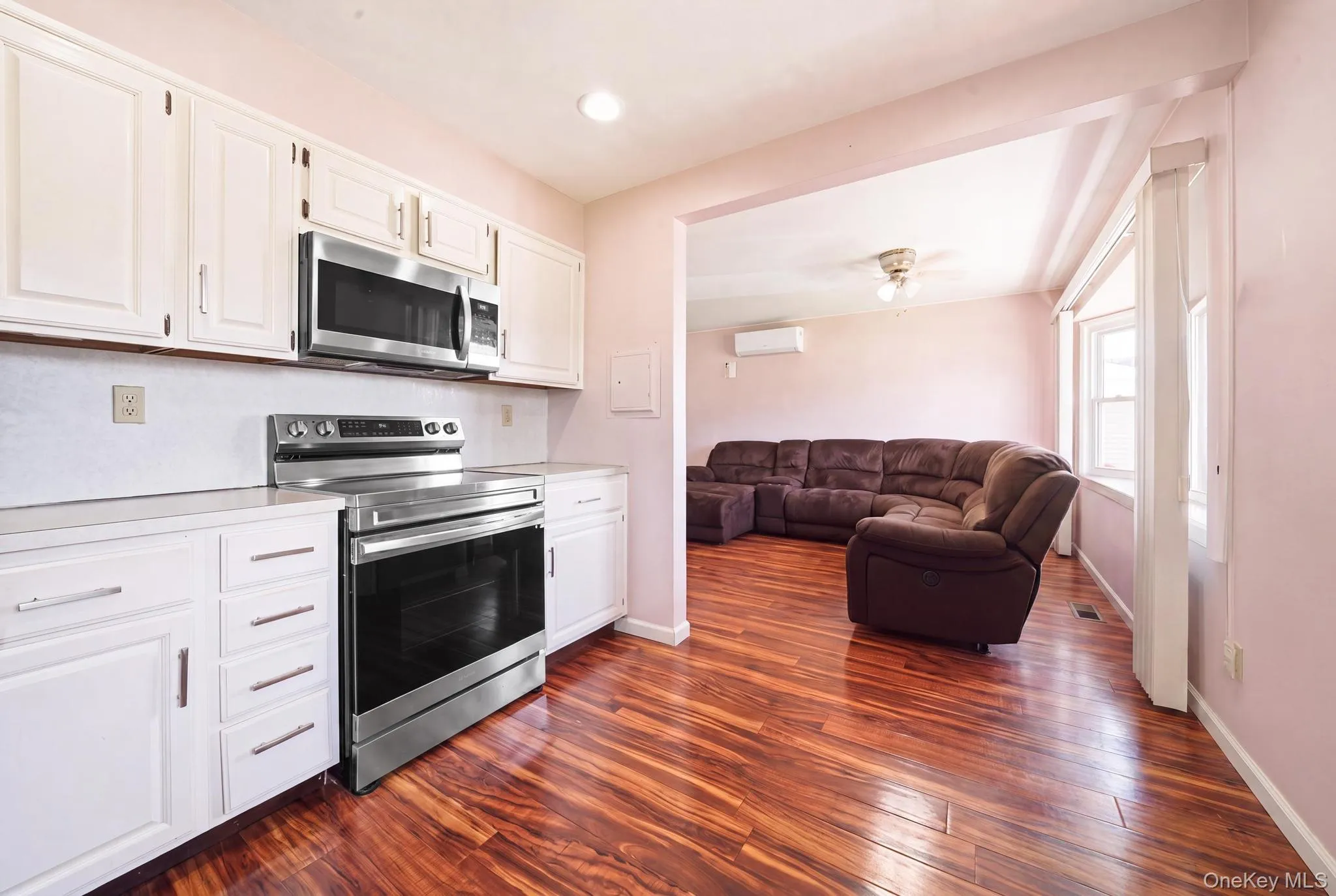 Kitchen featuring white cabinetry, stainless steel microwave, and a stainless steel electric range Kitchen featuring white cabinetry, stainless steel microwave, and a stainless steel electric range