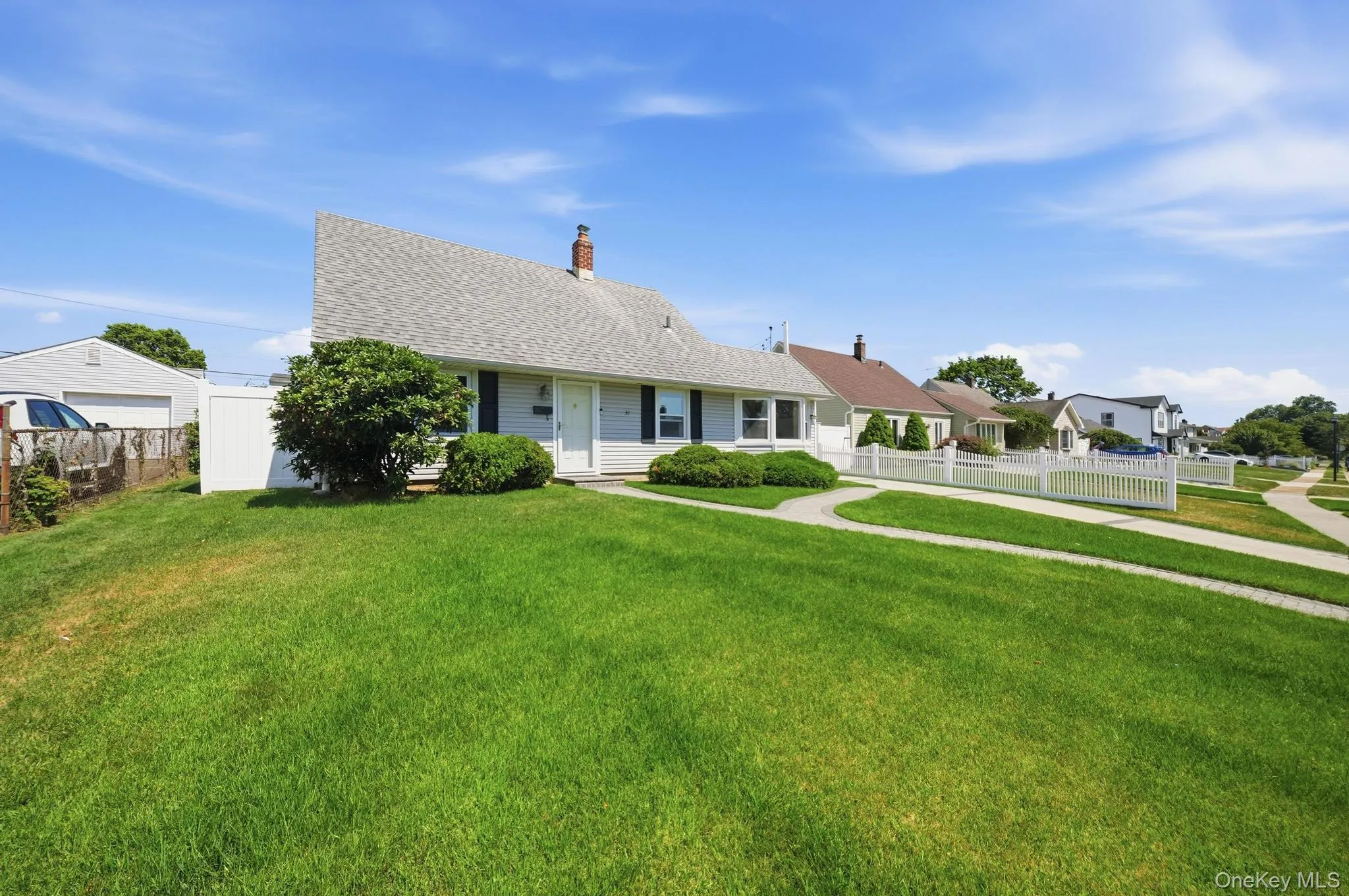 Single-story home featuring a gray shingle roof, light-colored siding, and dark shutters Single-story home featuring a gray shingle roof, light-colored siding, and dark shutters