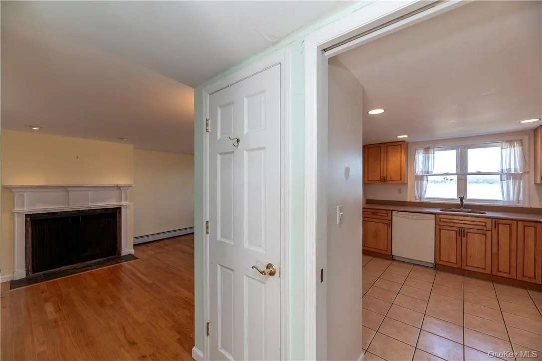 Kitchen featuring dishwasher, baseboard heating, light wood-type flooring, and sink Kitchen featuring dishwasher, baseboard heating, light wood-type flooring, and sink