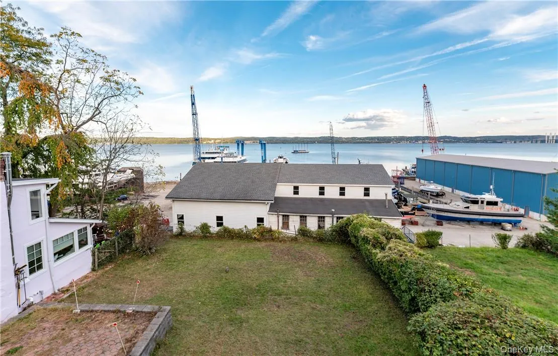 Back of property with a water view and a yard Back of property with a water view and a yard