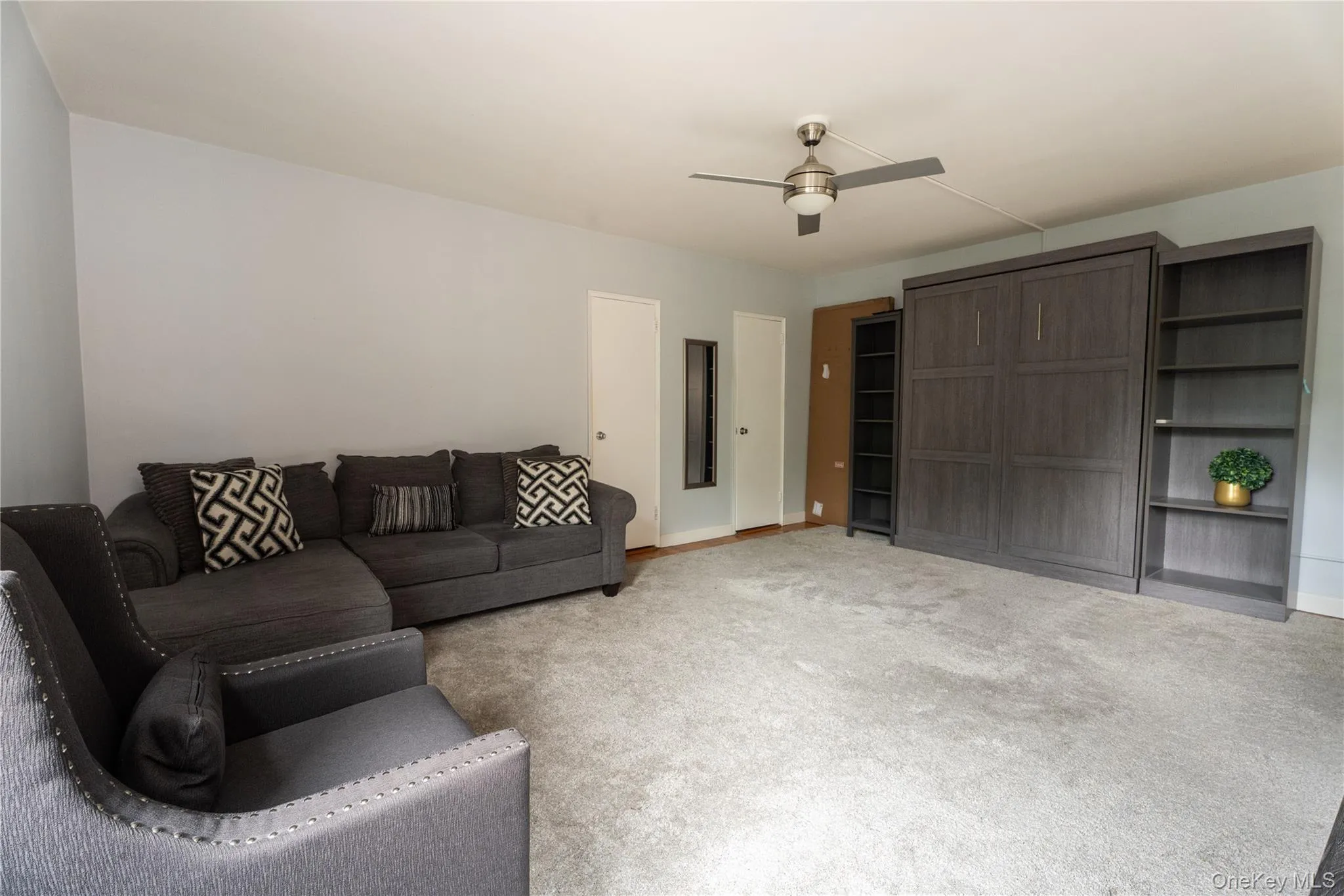 Spacious interior featuring light gray wall paint and a light gray carpeted floor Spacious interior featuring light gray wall paint and a light gray carpeted floor