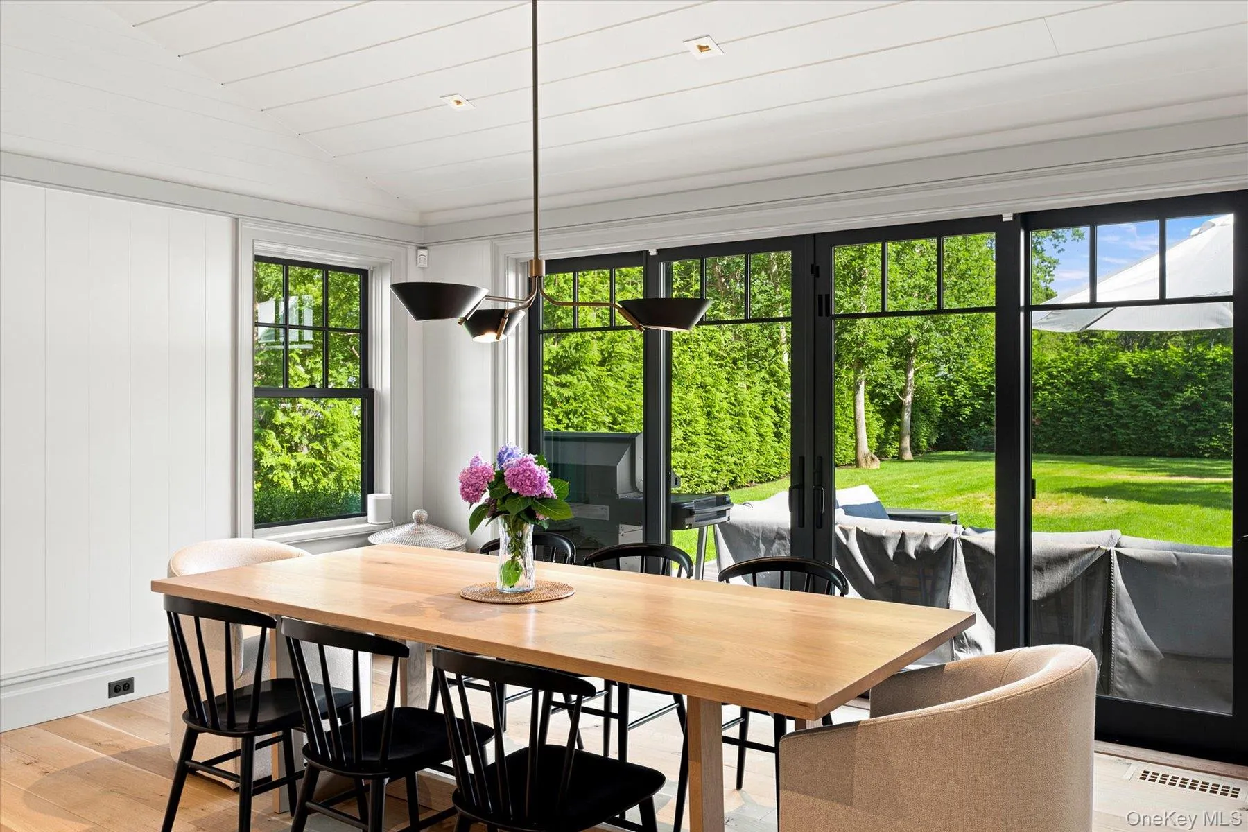 Dining area featuring shiplap ceiling, wood-finish flooring, and paneling Dining area featuring shiplap ceiling, wood-finish flooring, and paneling