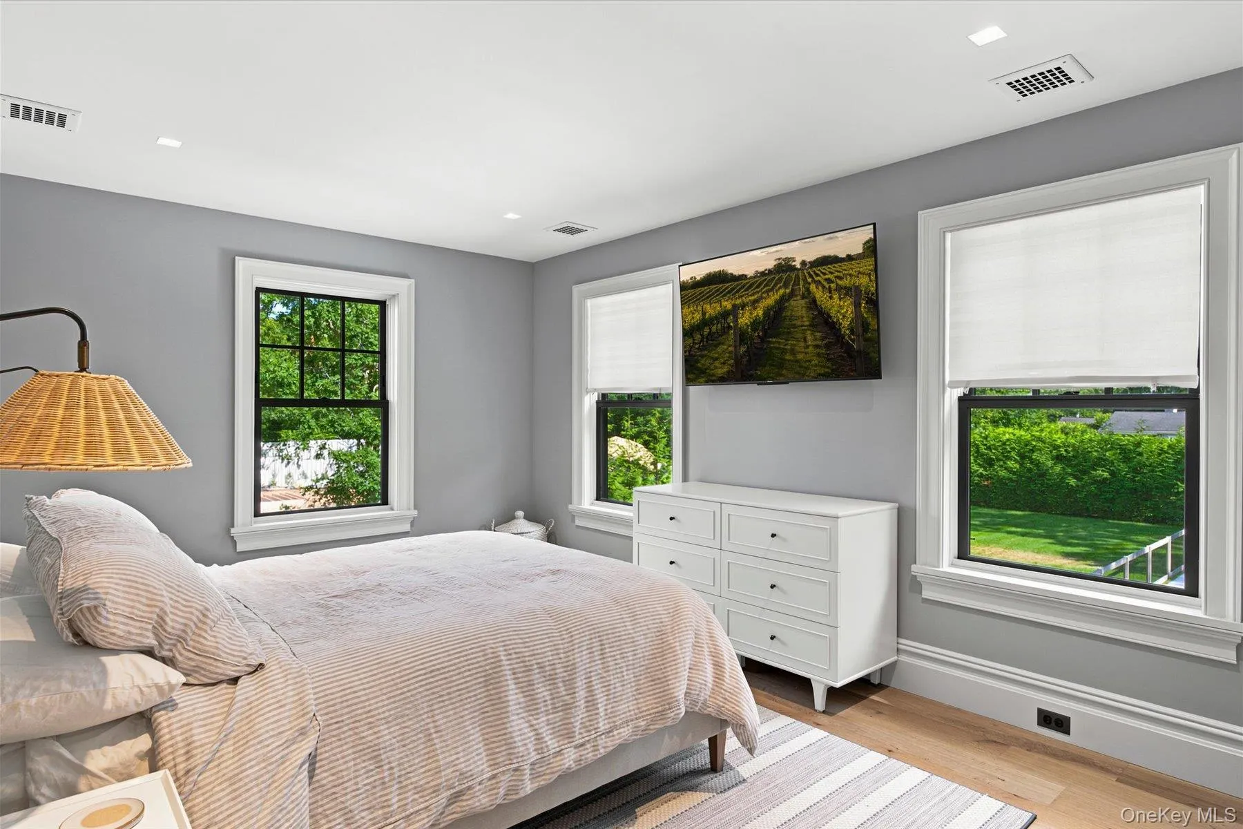 Room featuring light wood-finish flooring, recessed ceiling lights, and white baseboards Room featuring light wood-finish flooring, recessed ceiling lights, and white baseboards