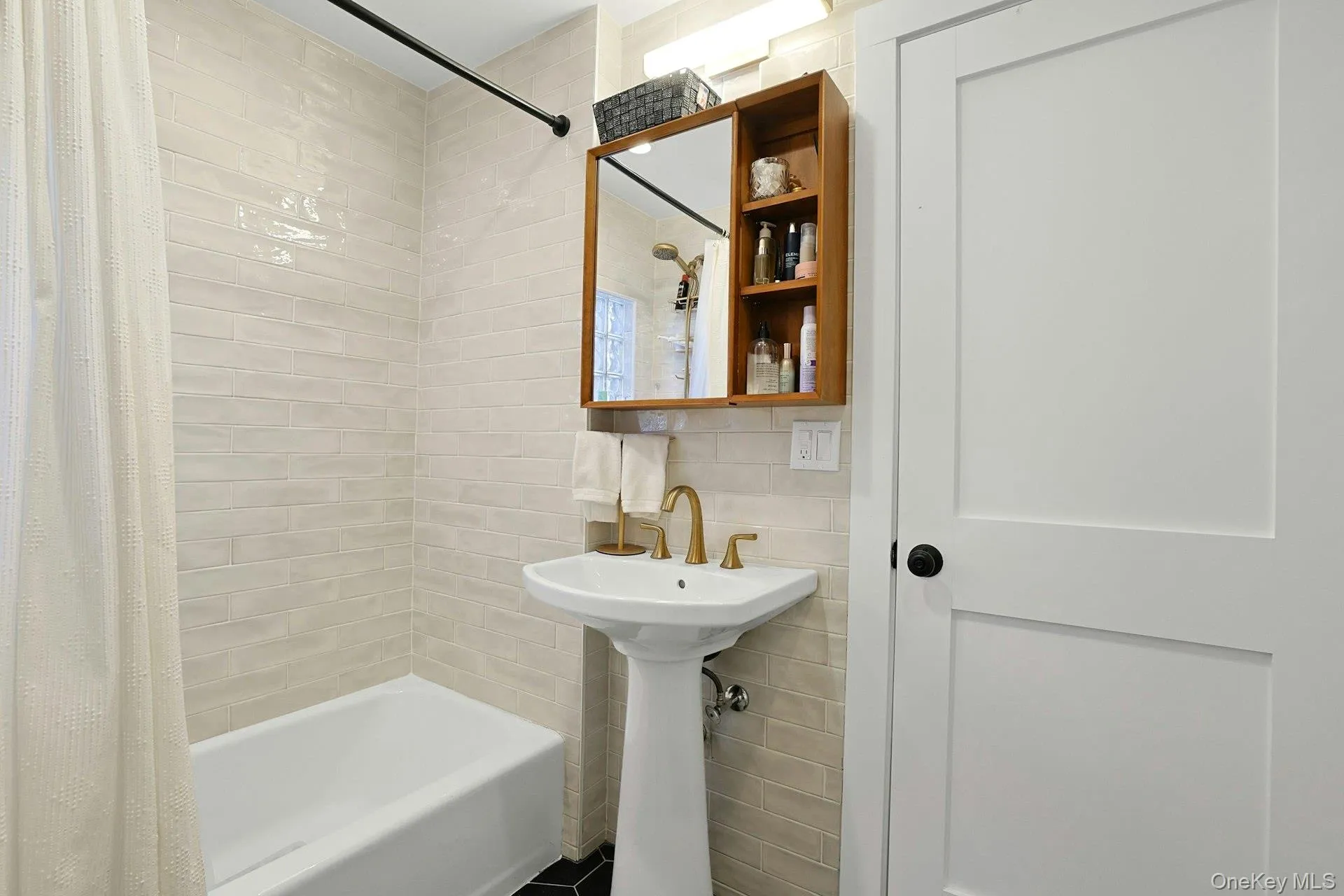 Bathroom with tile walls and shower / bath combo Bathroom with tile walls and shower / bath combo
