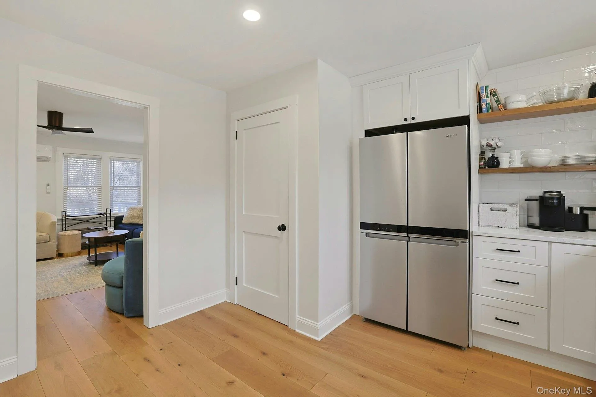 Kitchen featuring stainless steel appliances with open shelves, white cabinets, light countertops, recessed lighting, and decorative backsplash Kitchen featuring stainless steel appliances with open shelves, white cabinets, light countertops, recessed lighting, and decorative backsplash