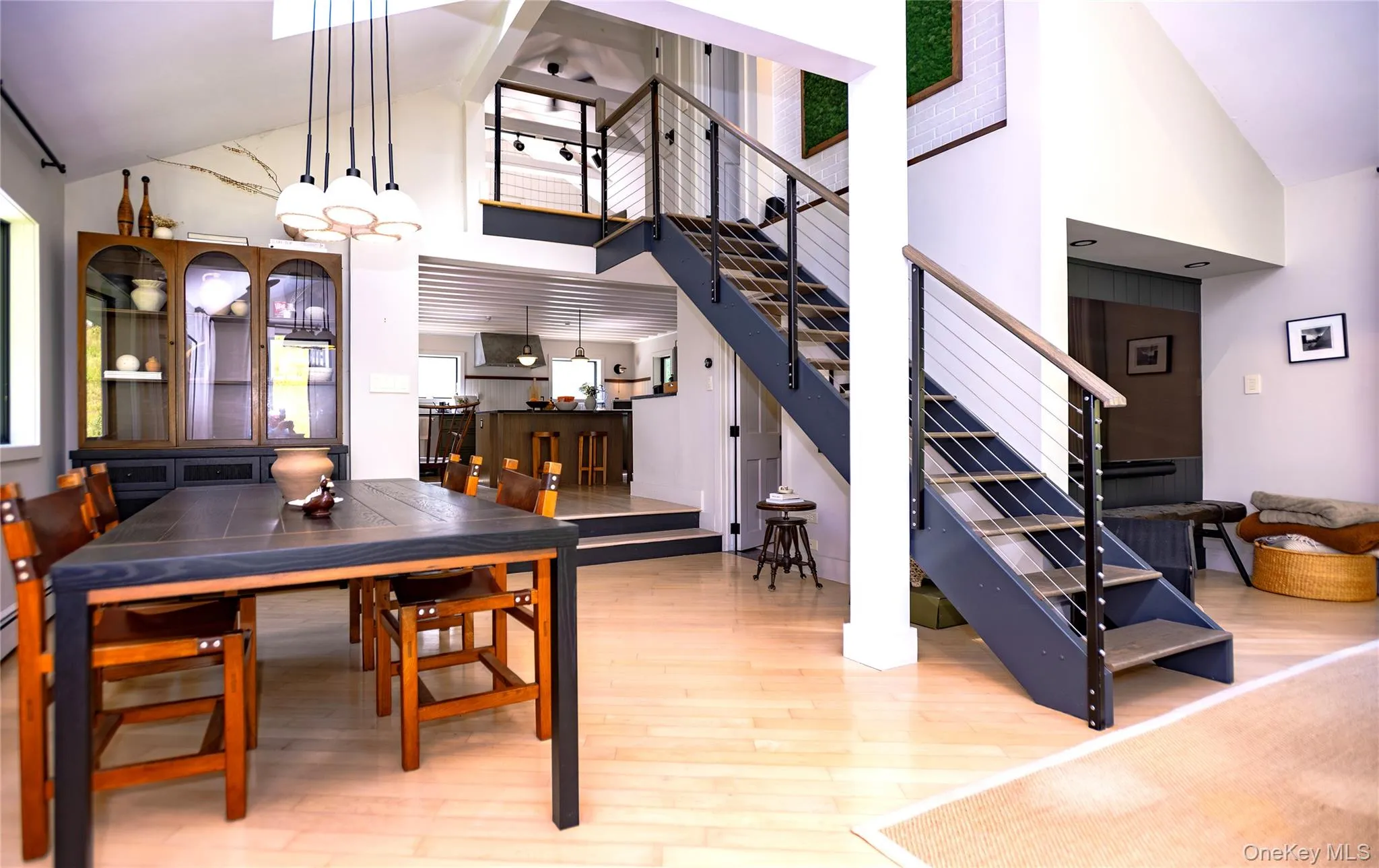 Open architecture with foreground dining room, kitchen and kitchen sitting room beyond and open staircase to second floor bedrooms. Open architecture with foreground dining room, kitchen and kitchen sitting room beyond and open staircase to second floor bedrooms.