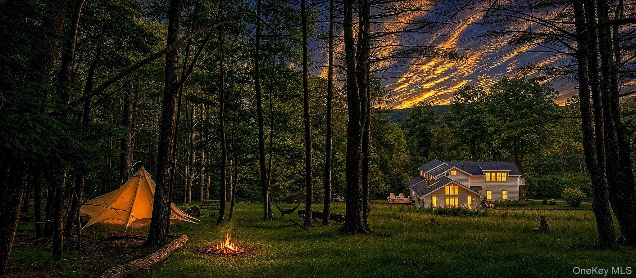 Twilight sunset view of the camp site with the home in the background from the hill-top forest entrance. Twilight sunset view of the camp site with the home in the background from the hill-top forest entrance.