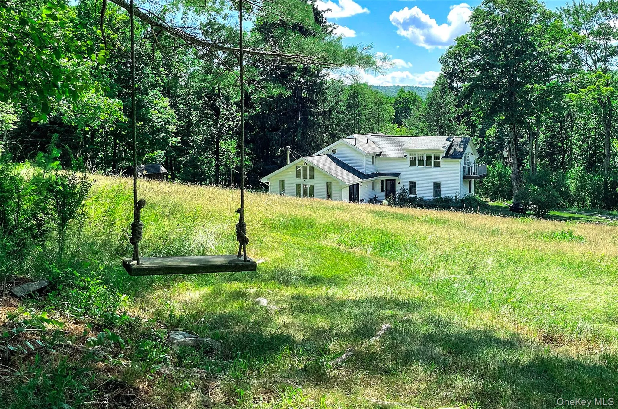 This swing, on the walking trail marks the entrance to the woodlands and offers a grand overview of the home against a dramatic background view of the Catskill mountain range in the background. This swing, on the walking trail marks the entrance to the woodlands and offers a grand overview of the home against a dramatic background view of the Catskill mountain range in the background.