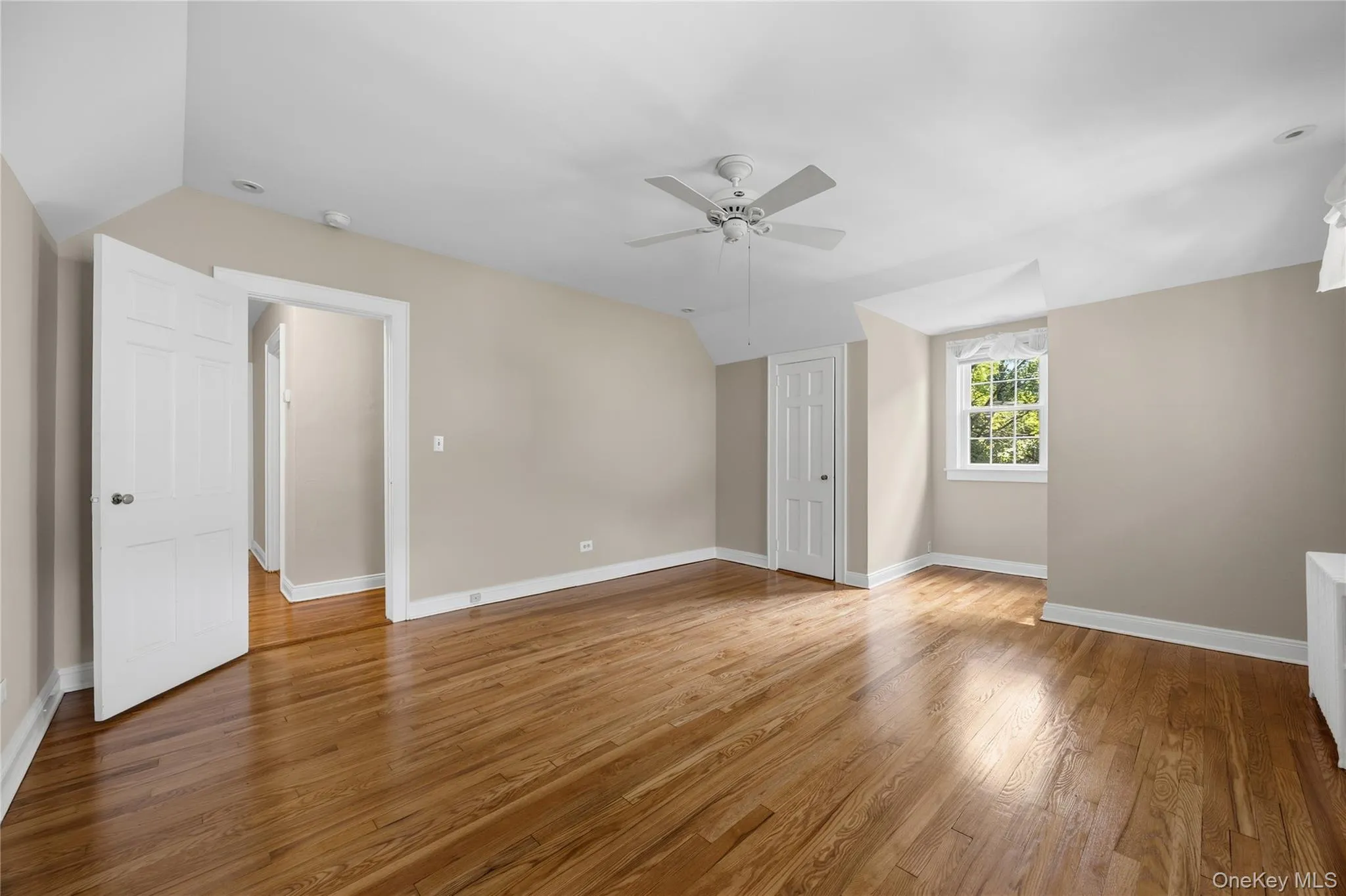Gleaming hardwood floors in the spacious Primary Bedroom with ceiling fan Gleaming hardwood floors in the spacious Primary Bedroom with ceiling fan