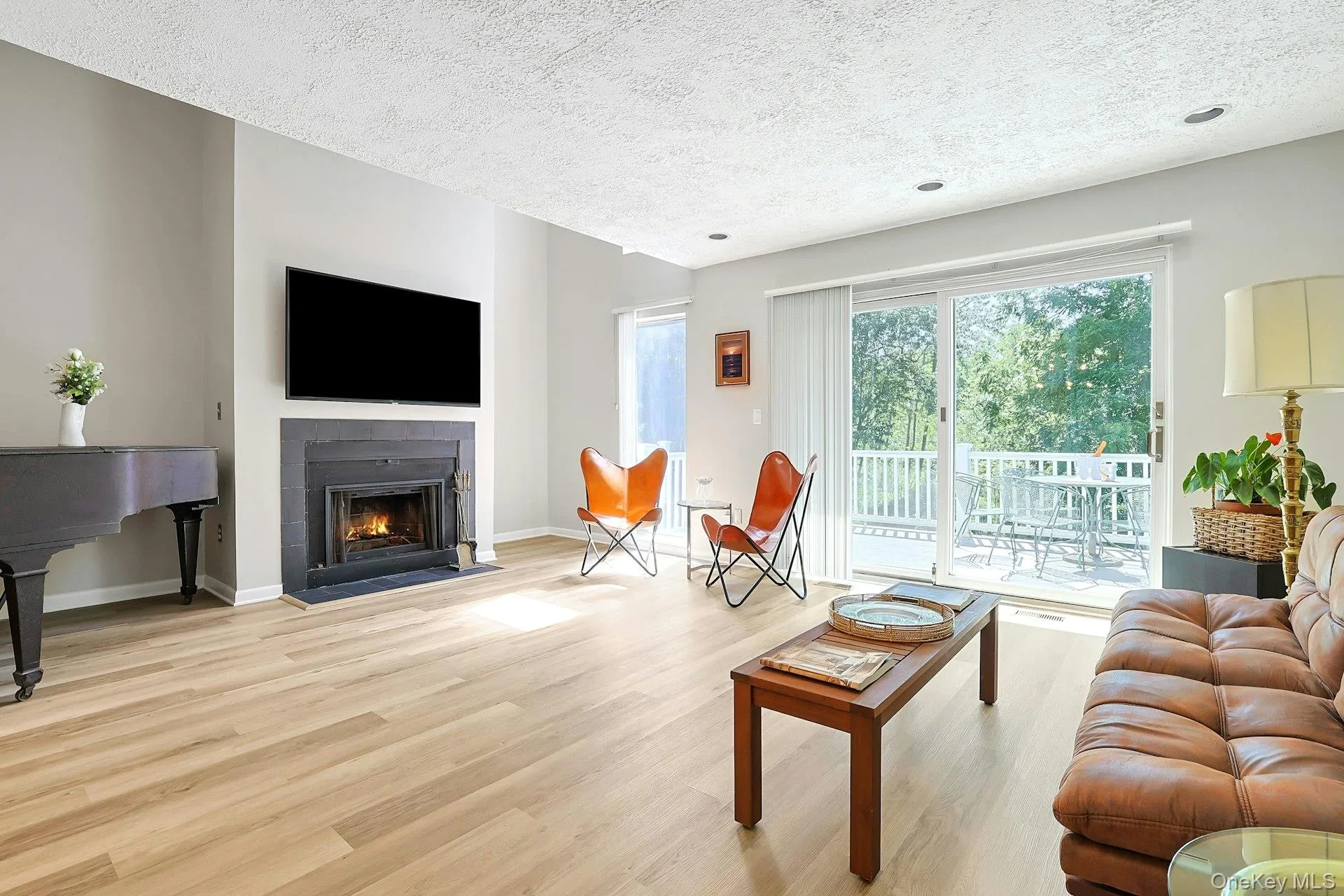 Spacious living room with hardwood floors, a fireplace and sliding glass doors leading out to the patio, creating a comfortable indoor-outdoor flow. Spacious living room with hardwood floors, a fireplace and sliding glass doors leading out to the patio, creating a comfortable indoor-outdoor flow.