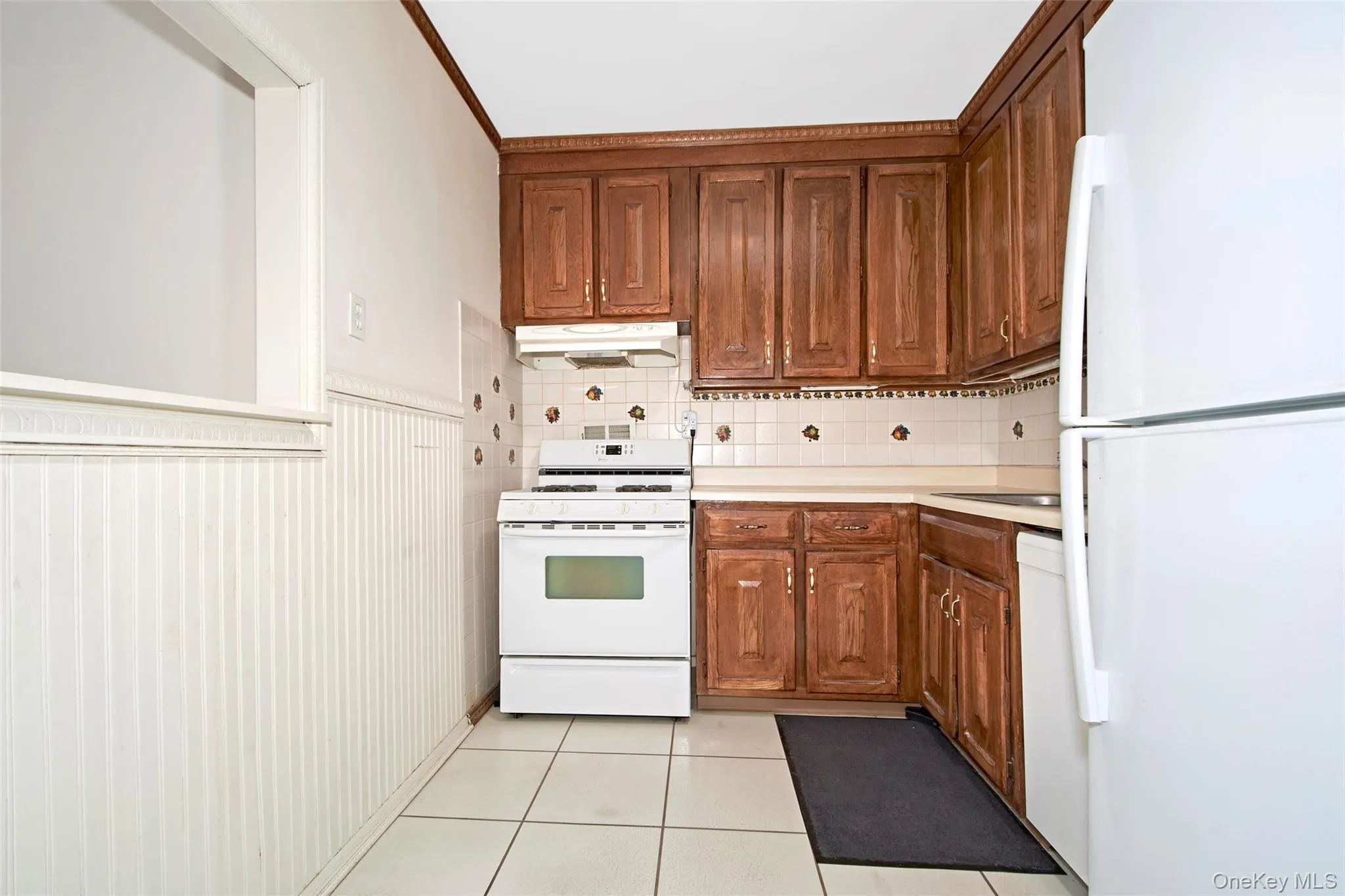 The kitchen has newer appliances, tile backsplash and window that overlooks the living room. The kitchen has newer appliances, tile backsplash and window that overlooks the living room.