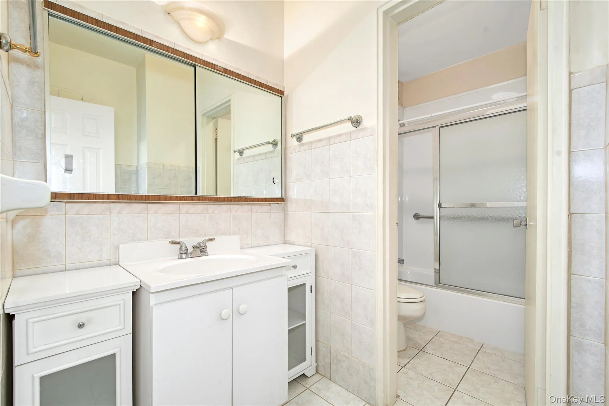 Bathroom features a separate sink area and a glass shower door. Bathroom features a separate sink area and a glass shower door.