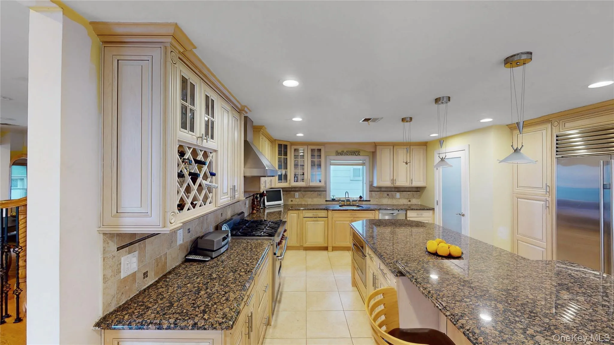Spacious kitchen featuring light wood cabinetry, granite countertops, stainless steel appliances, a large center island, and recessed lighting Spacious kitchen featuring light wood cabinetry, granite countertops, stainless steel appliances, a large center island, and recessed lighting