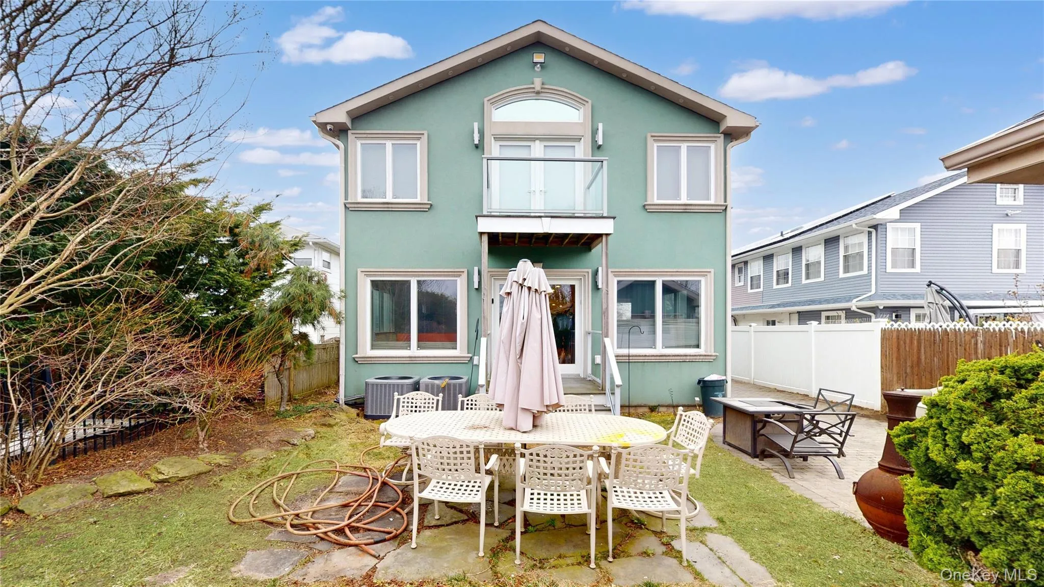 Two-story exterior with a stucco finish and a second-floor balcony featuring glass railing Two-story exterior with a stucco finish and a second-floor balcony featuring glass railing