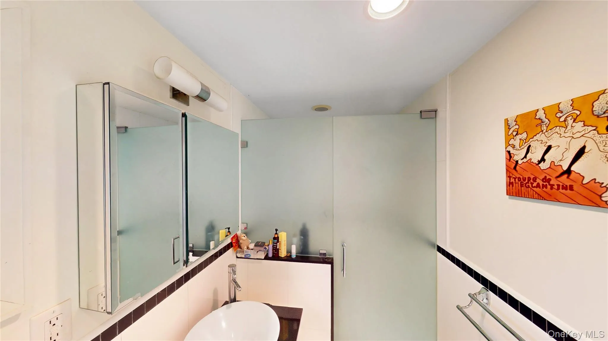 Bathroom featuring a frameless frosted glass shower enclosure, contemporary vessel sink, wall-mounted medicine cabinet with mirrored doors, and recessed ceiling lighting Bathroom featuring a frameless frosted glass shower enclosure, contemporary vessel sink, wall-mounted medicine cabinet with mirrored doors, and recessed ceiling lighting