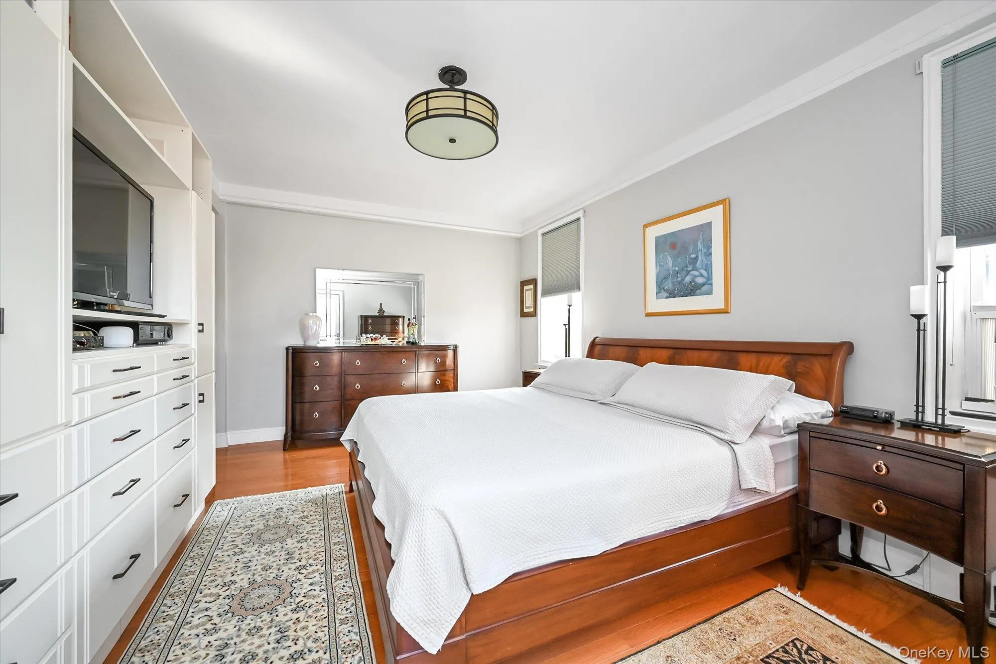 The king-size primary bedroom features custom built in cabinetry for substantial added storage, and a large private decked balcony with open views toward Manhattan The king-size primary bedroom features custom built in cabinetry for substantial added storage, and a large private decked balcony with open views toward Manhattan