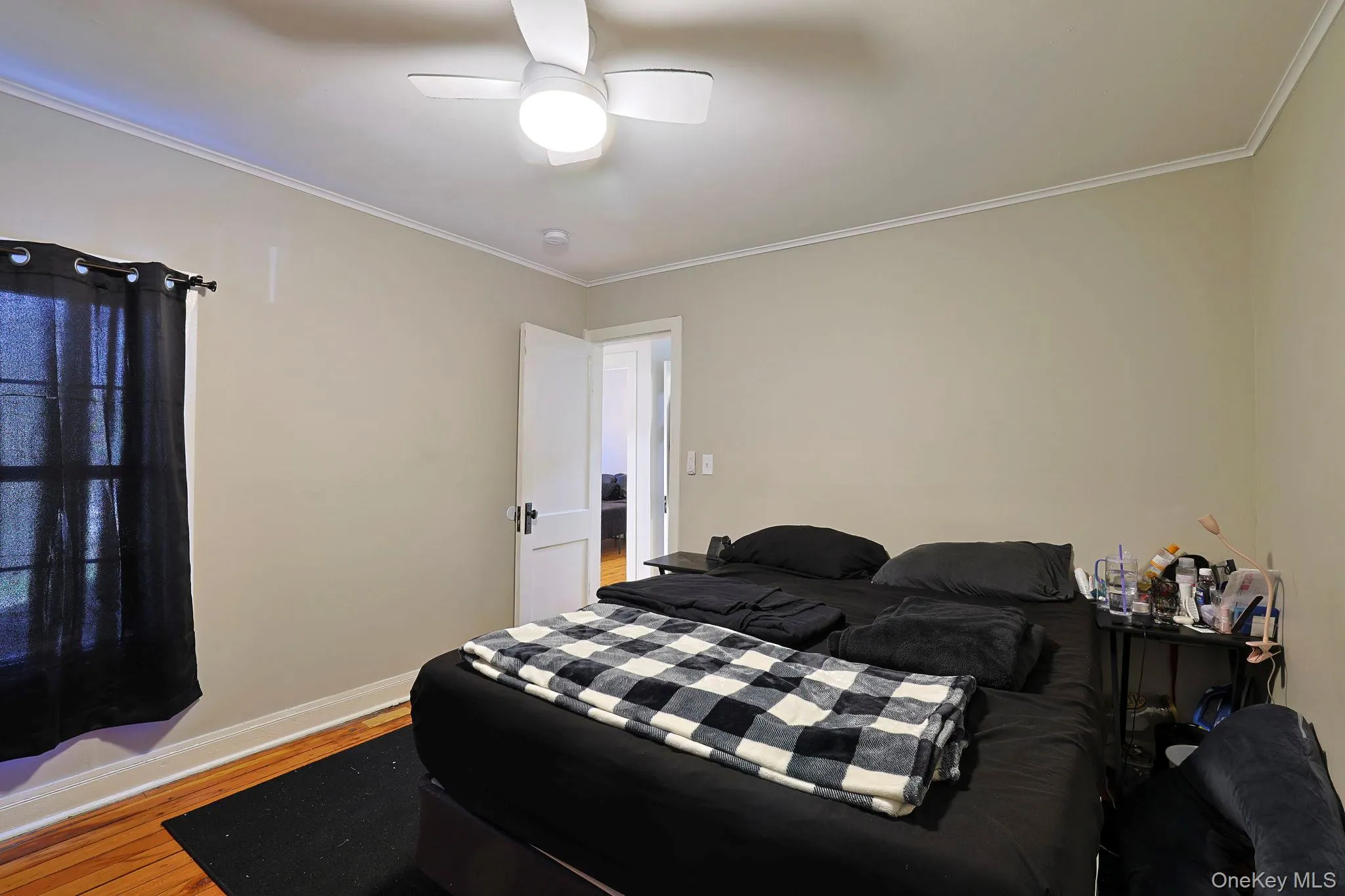 Bedroom with ceiling fan, baseboards, ornamental molding, and wood finished floors Bedroom with ceiling fan, baseboards, ornamental molding, and wood finished floors