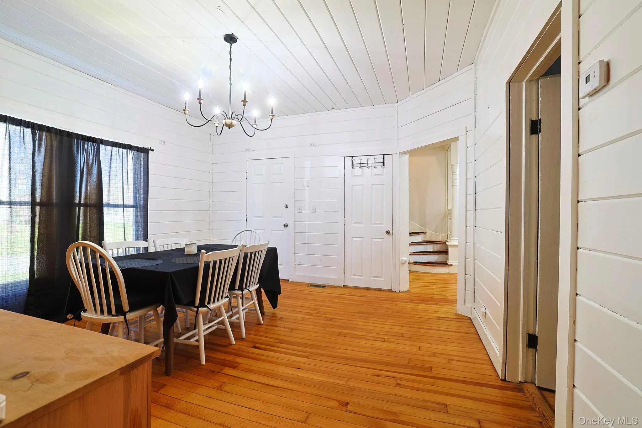 Dining space with wooden ceiling, an inviting chandelier, light wood-style floors, and stairway Dining space with wooden ceiling, an inviting chandelier, light wood-style floors, and stairway