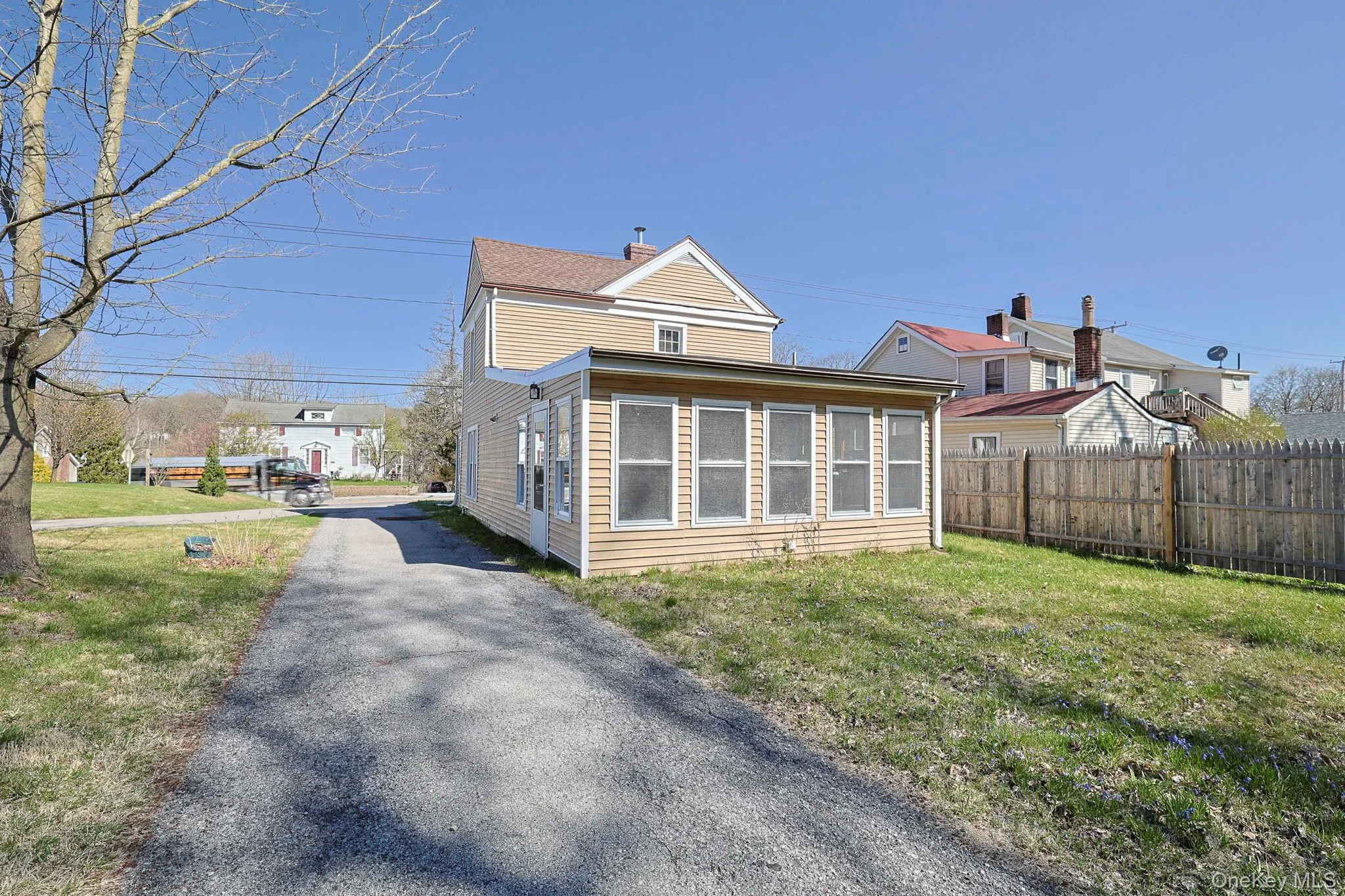 Back of property with fence, a lawn, and driveway Back of property with fence, a lawn, and driveway
