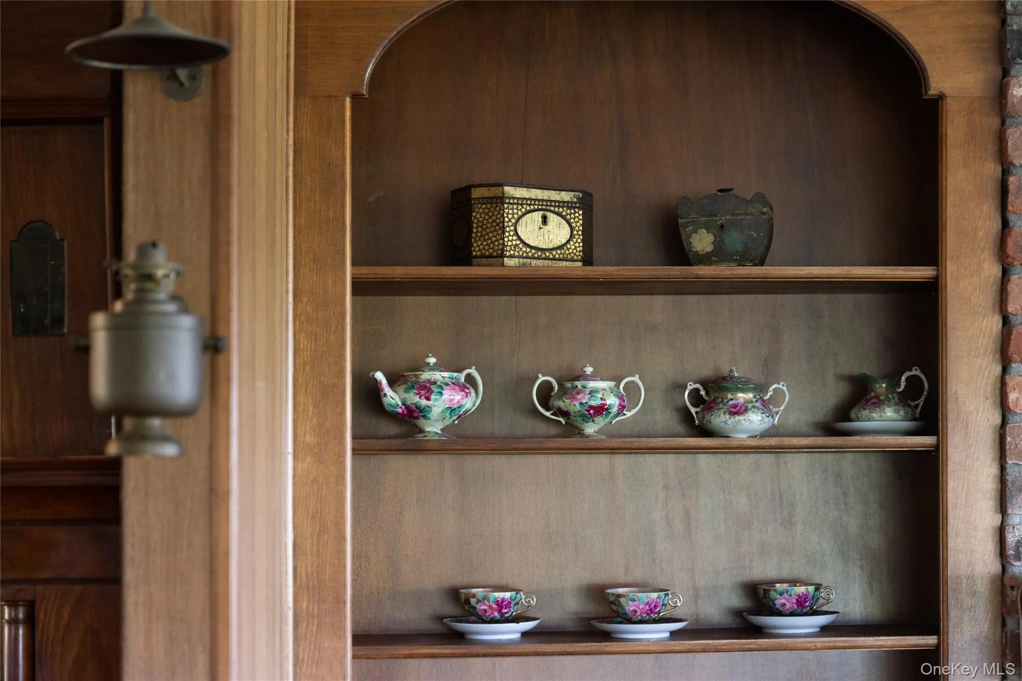 Charming details with wooden shelving unit featuring an arched top and multiple display shelves Charming details with wooden shelving unit featuring an arched top and multiple display shelves