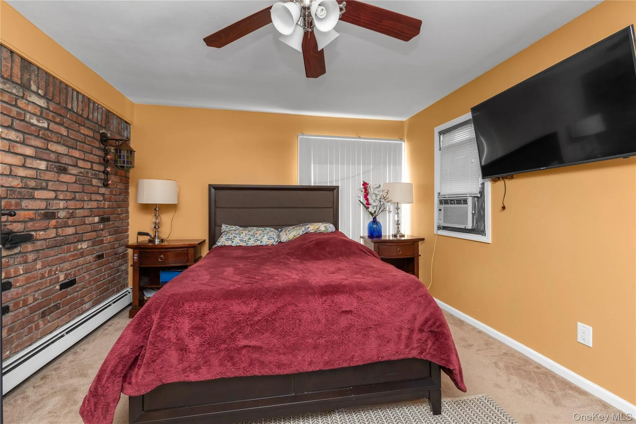 Bedroom with baseboard heating, carpet, ceiling fan, and cooling unit Bedroom with baseboard heating, carpet, ceiling fan, and cooling unit
