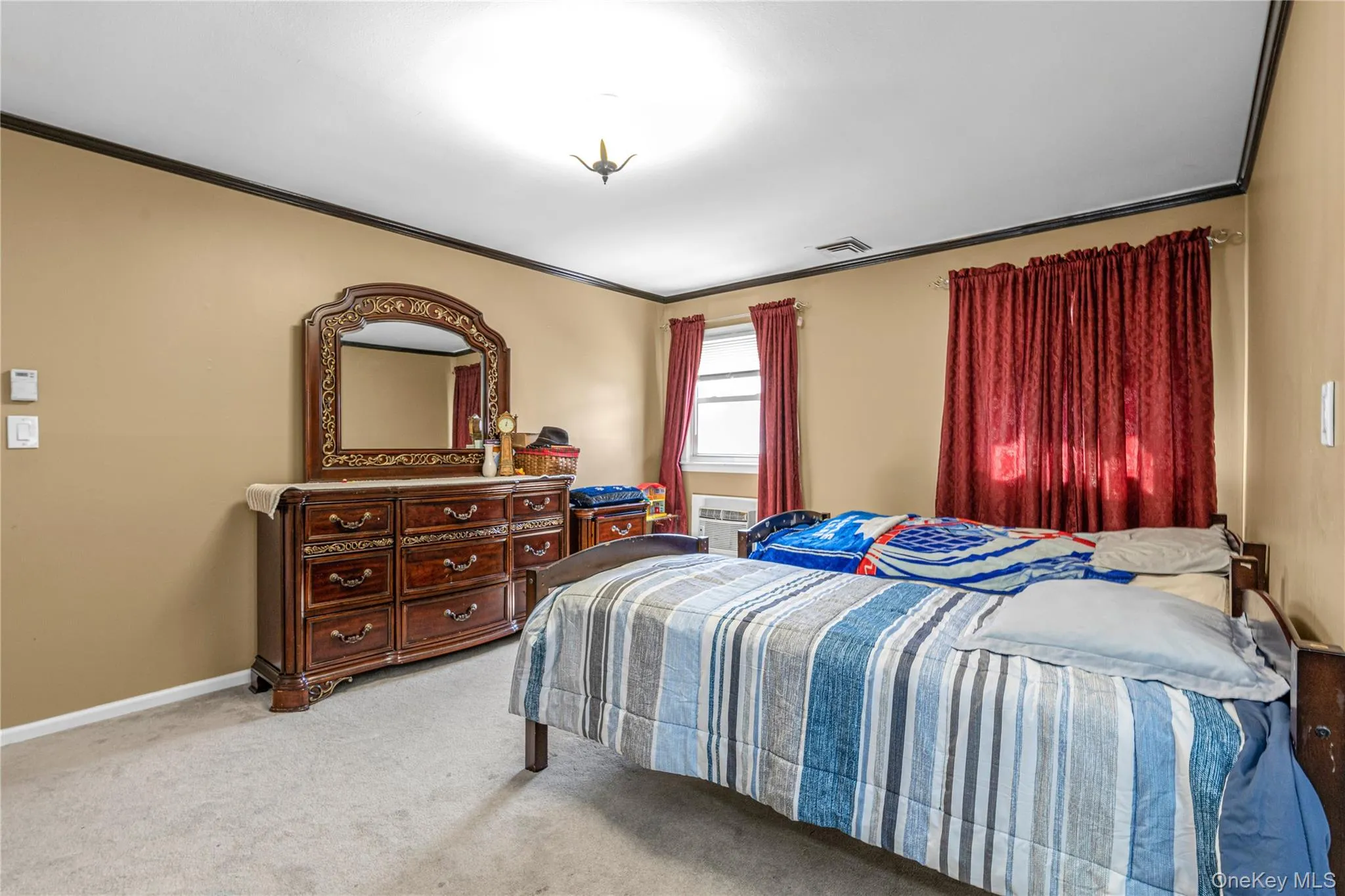 Bedroom with ornamental molding and light colored carpet Bedroom with ornamental molding and light colored carpet