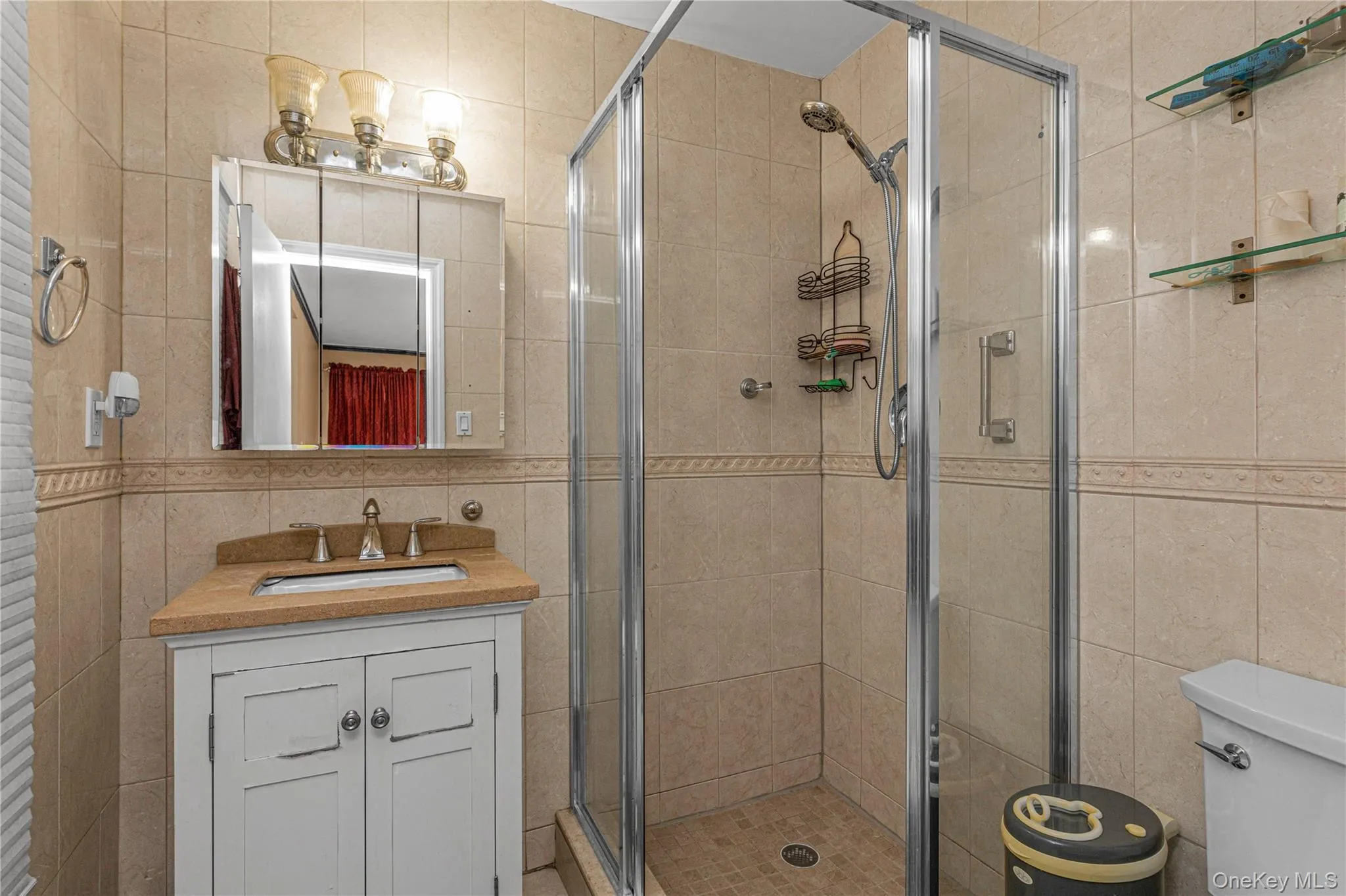 Full bathroom featuring tile walls, vanity, and a stall shower Full bathroom featuring tile walls, vanity, and a stall shower