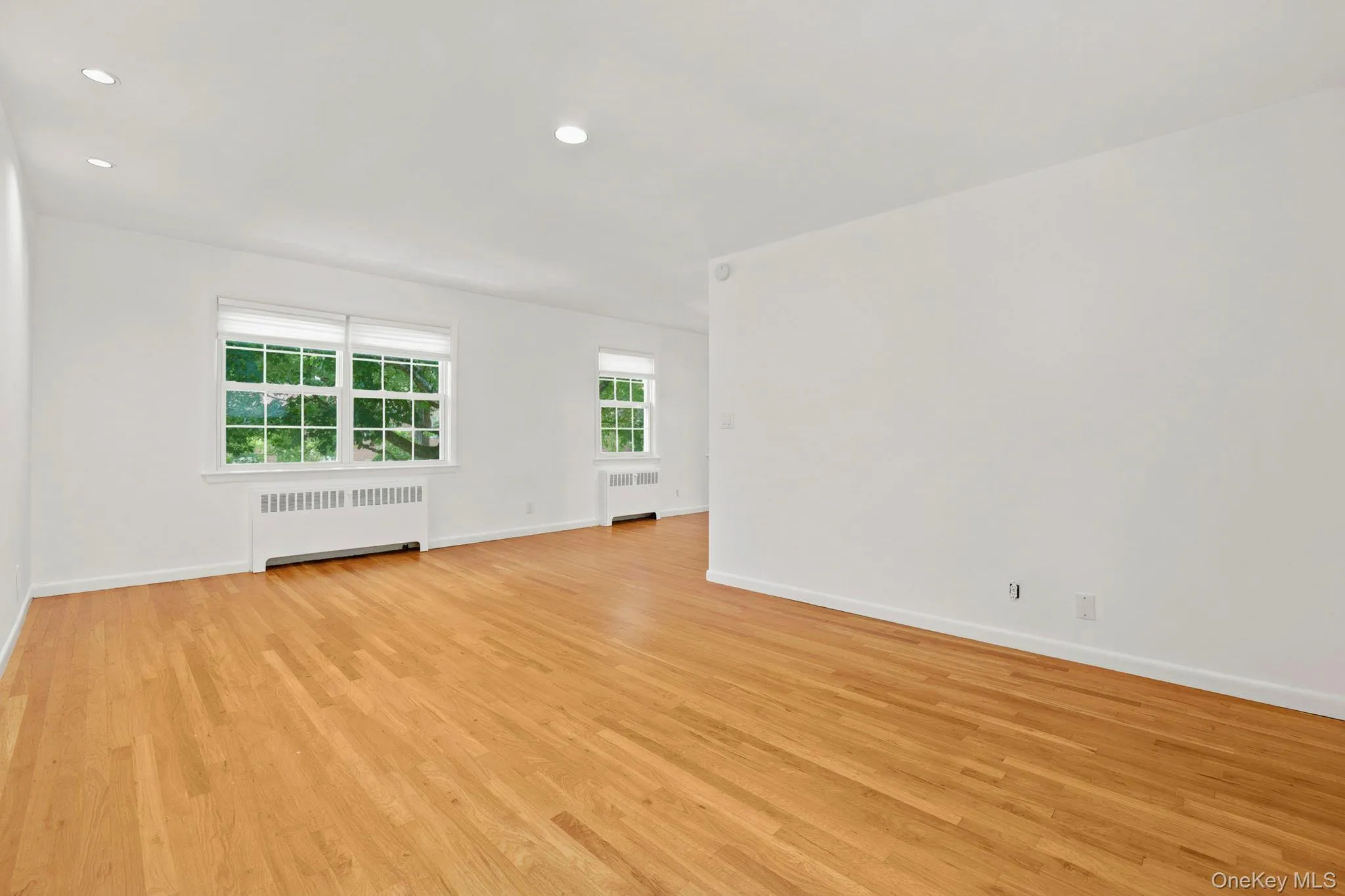 Alternate view of the living room with its beautiful hardwood floors and the south-facing windows overlooking the courtyard and its trees and gardens Alternate view of the living room with its beautiful hardwood floors and the south-facing windows overlooking the courtyard and its trees and gardens