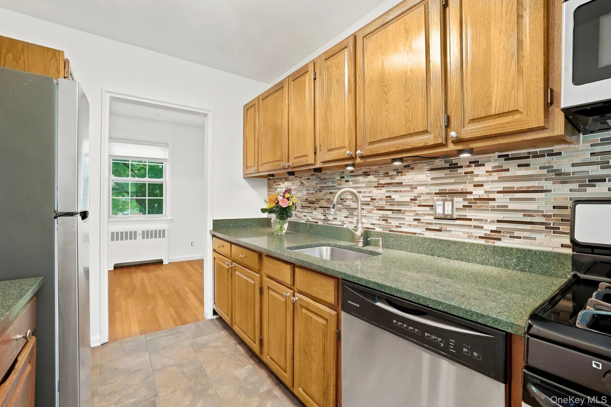 There are Frigidaire stainless steel appliances, inclusive of a gas range, and a stylish glass tile backsplash, highlighted by the undercounter lighting There are Frigidaire stainless steel appliances, inclusive of a gas range, and a stylish glass tile backsplash, highlighted by the undercounter lighting