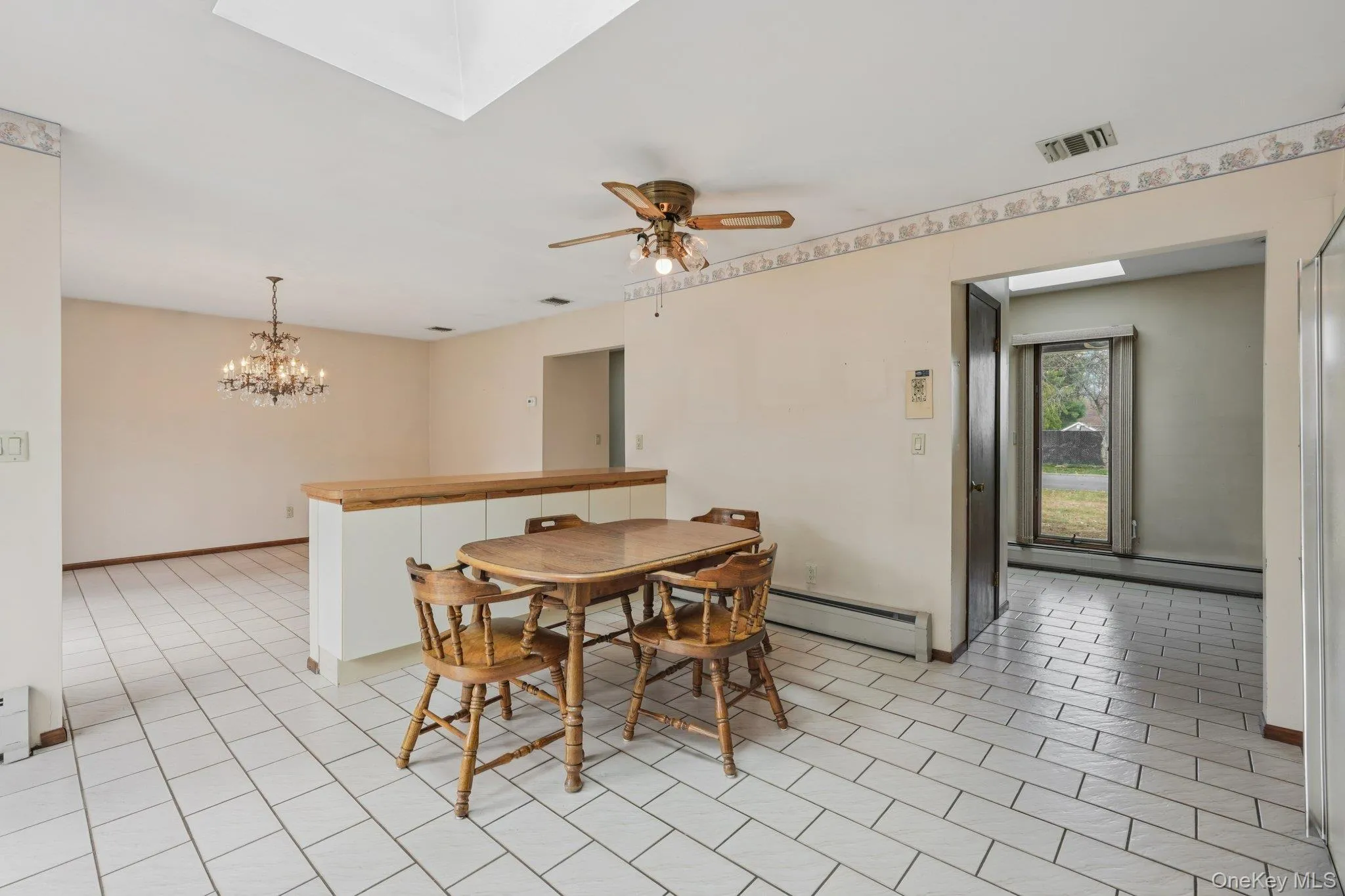 kitchen with a skylight, a baseboard radiator, and ceiling fan kitchen with a skylight, a baseboard radiator, and ceiling fan
