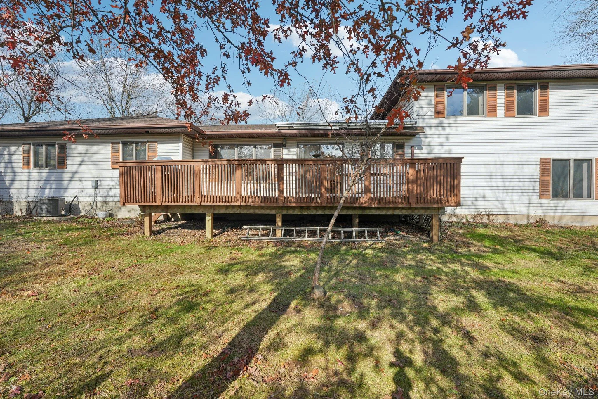 Rear view of property with a wooden deck and a yard Rear view of property with a wooden deck and a yard