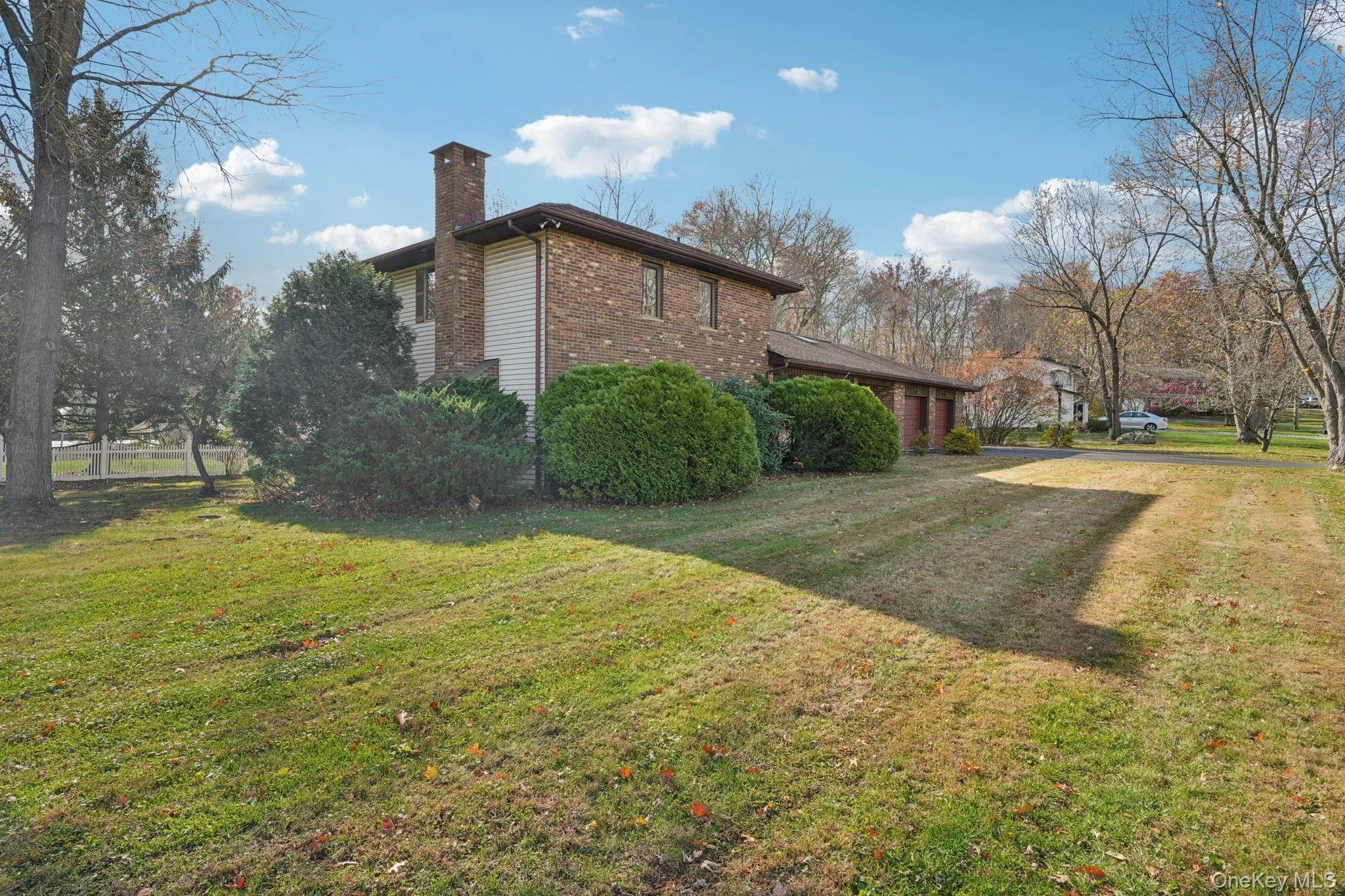 View of home's exterior with a chimney, a lawn, and brick siding View of home's exterior with a chimney, a lawn, and brick siding