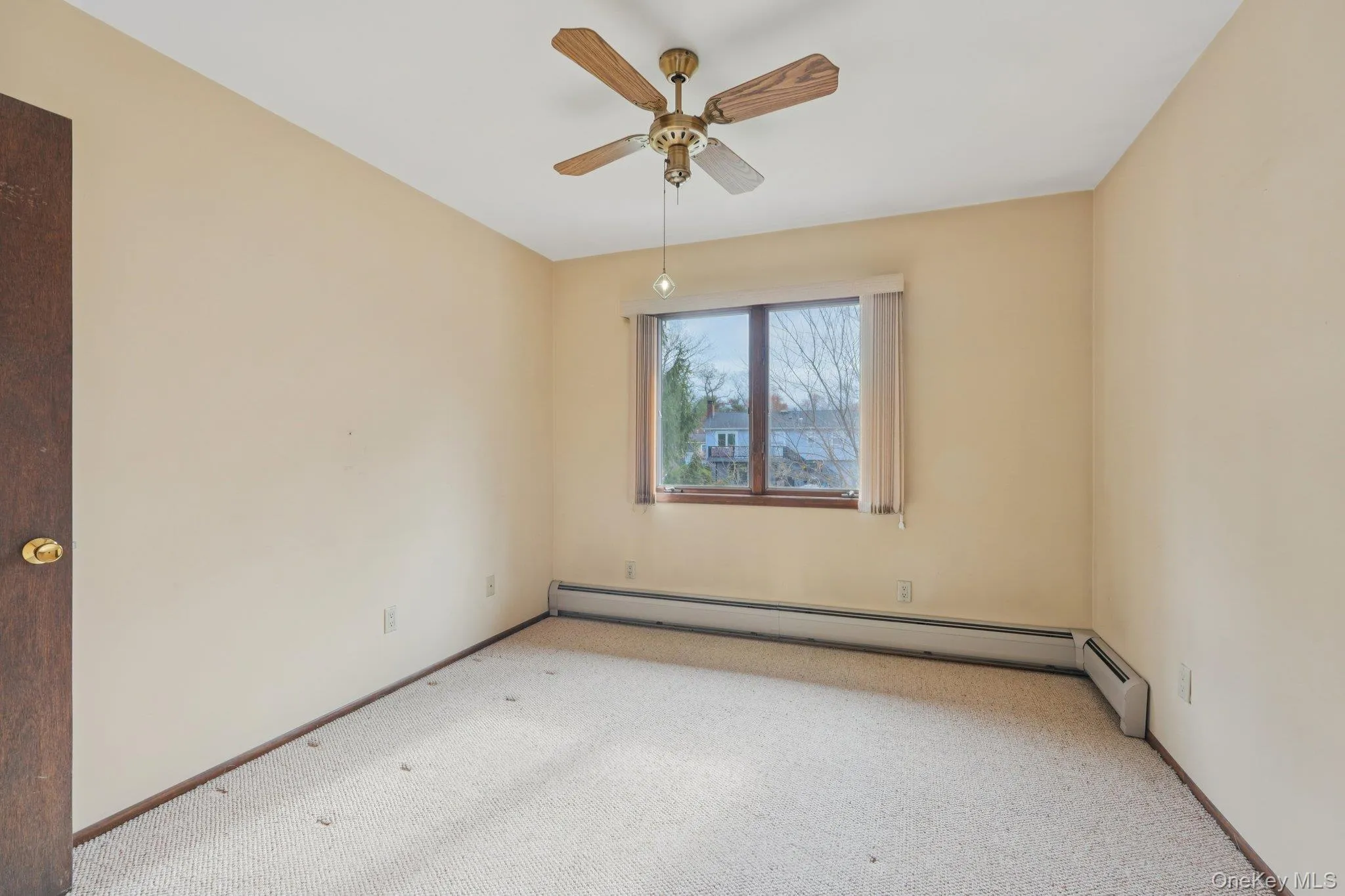Spare room with carpet, ceiling fan, and a baseboard heating unit Spare room with carpet, ceiling fan, and a baseboard heating unit