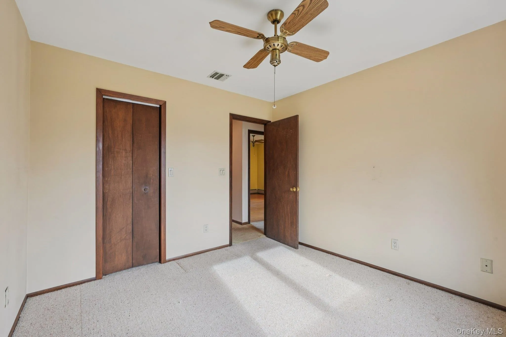 Unfurnished bedroom with a closet, a ceiling fan, and carpet flooring Unfurnished bedroom with a closet, a ceiling fan, and carpet flooring