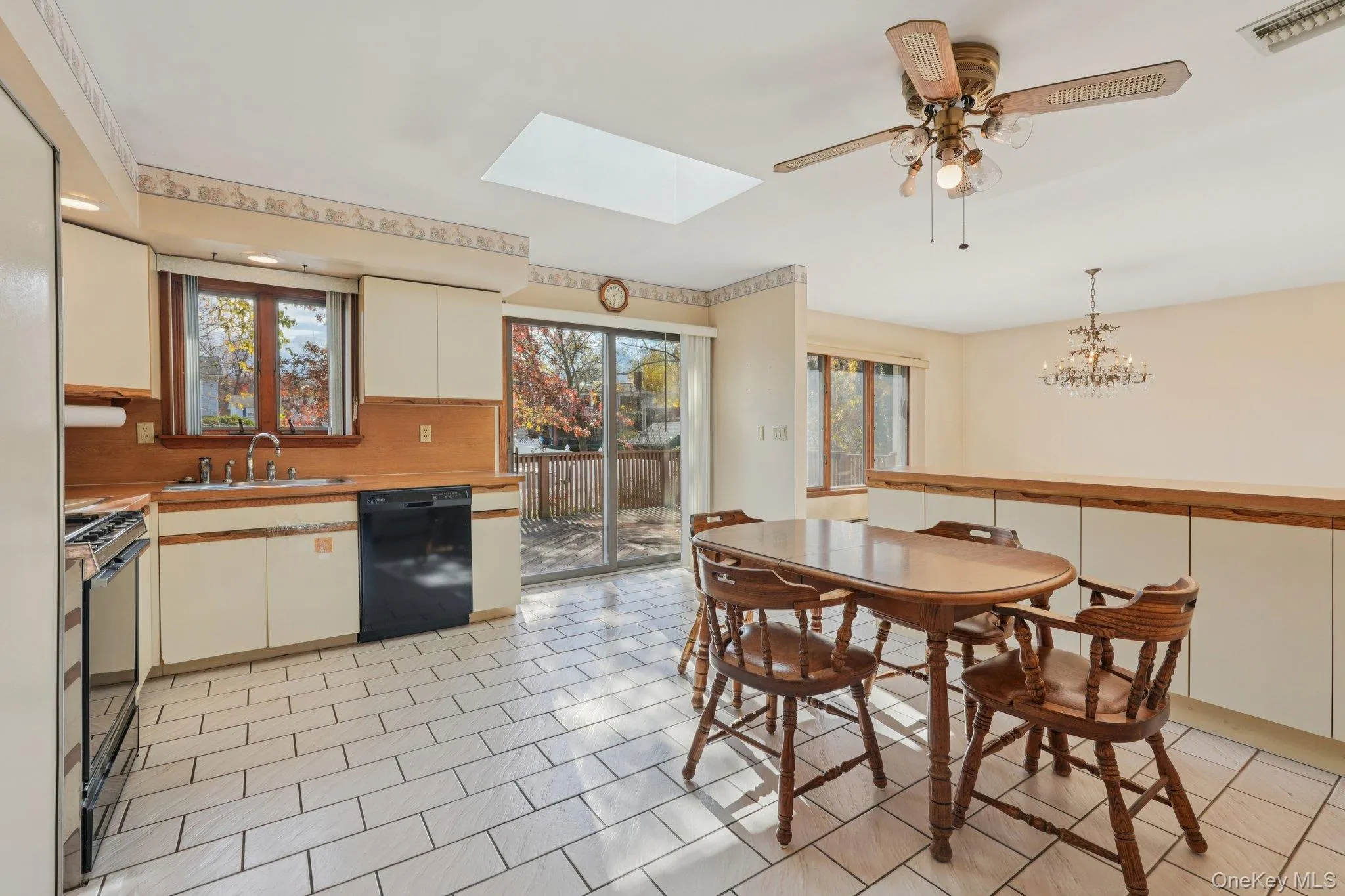 Kitchen featuring a skylight, black appliances, light countertops, and plenty of natural light Kitchen featuring a skylight, black appliances, light countertops, and plenty of natural light