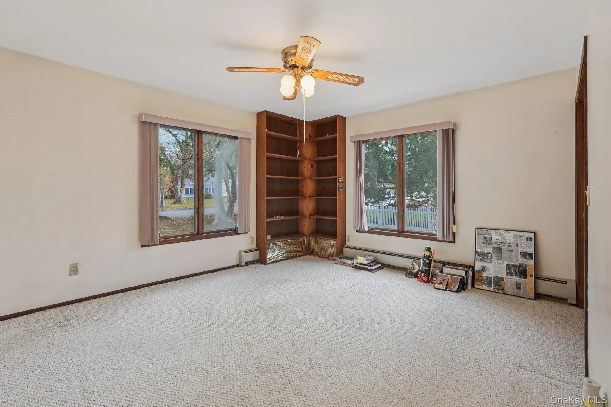Empty room featuring carpet floors, a baseboard heating unit, and a ceiling fan Empty room featuring carpet floors, a baseboard heating unit, and a ceiling fan