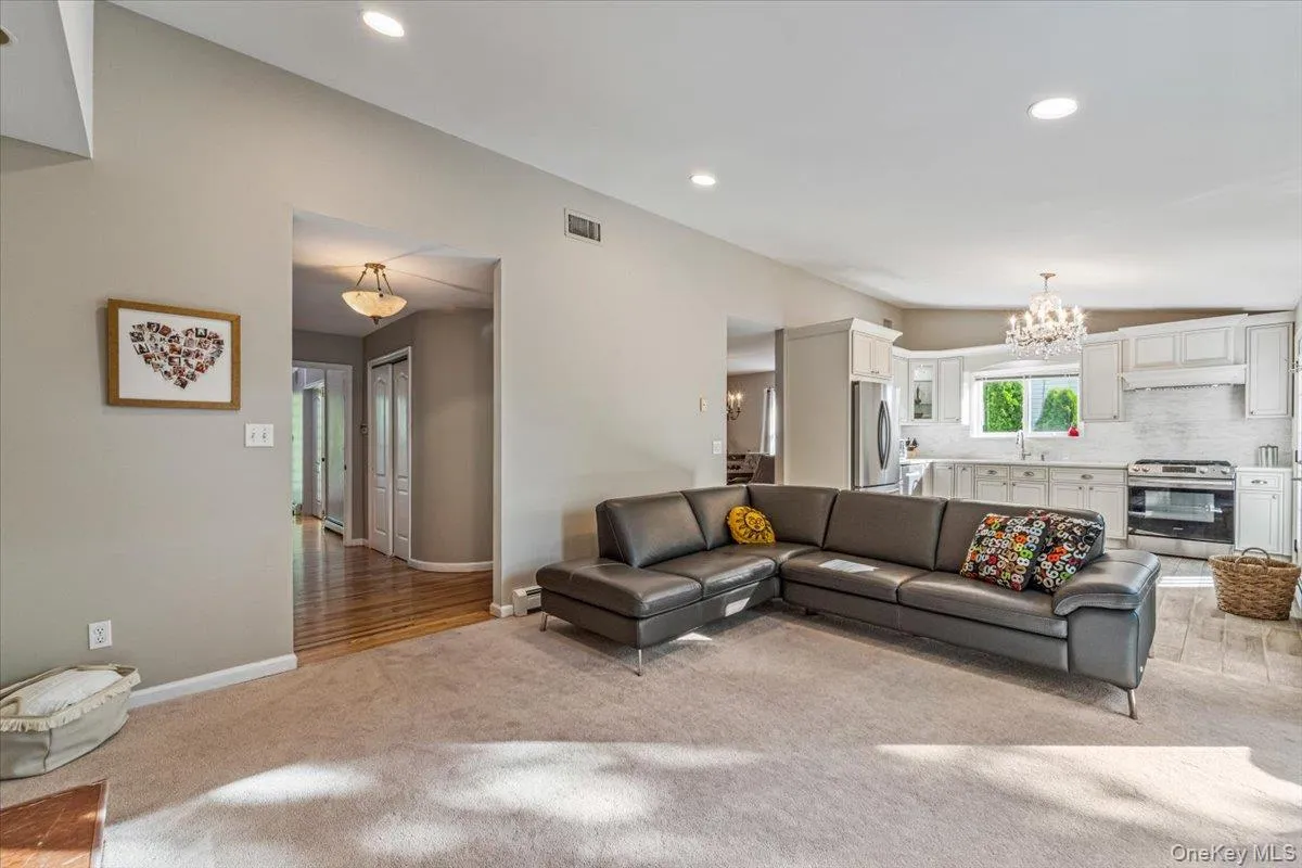 Expansive living area with recessed lighting and neutral wall tones Expansive living area with recessed lighting and neutral wall tones