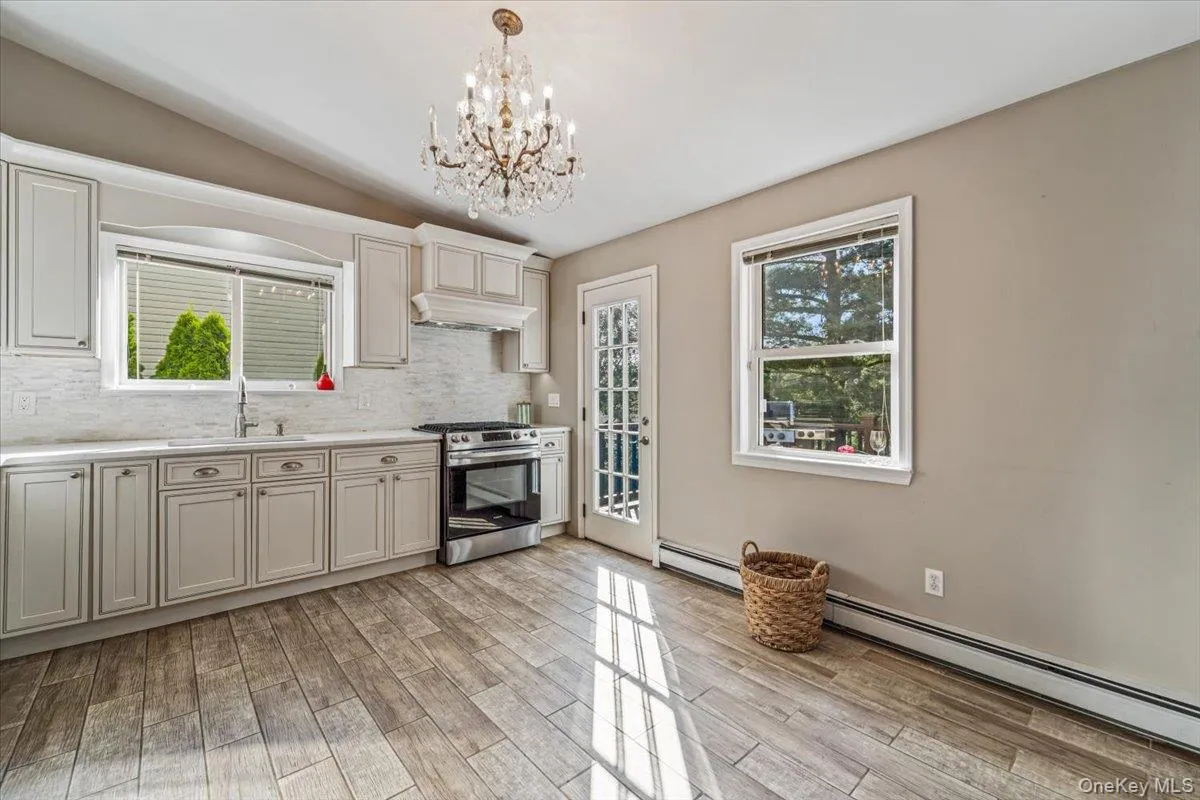 Kitchen featuring light wood-finish flooring and a crystal chandelier Kitchen featuring light wood-finish flooring and a crystal chandelier