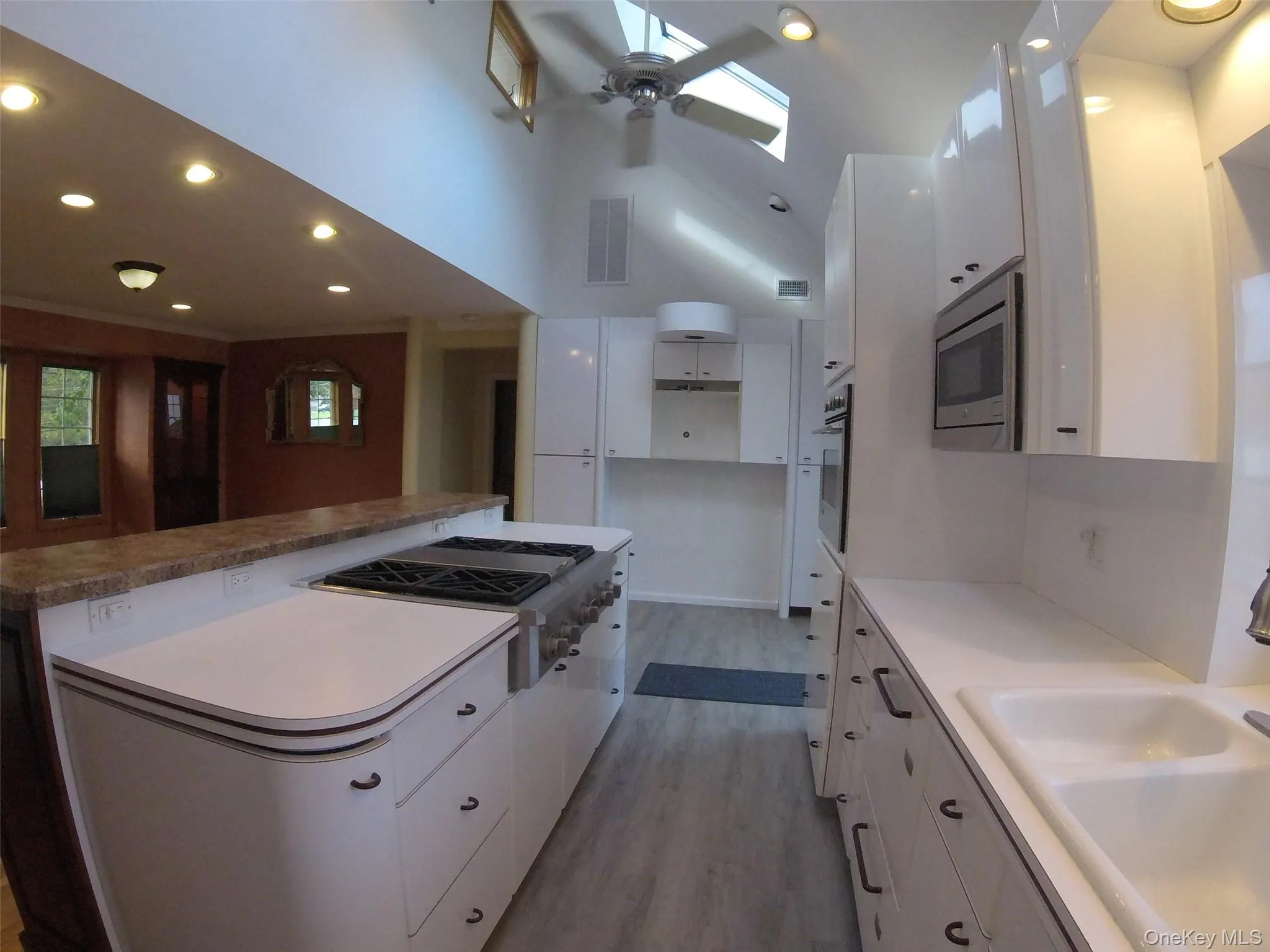 Modern kitchen featuring white cabinetry and light wood-finish flooring Modern kitchen featuring white cabinetry and light wood-finish flooring