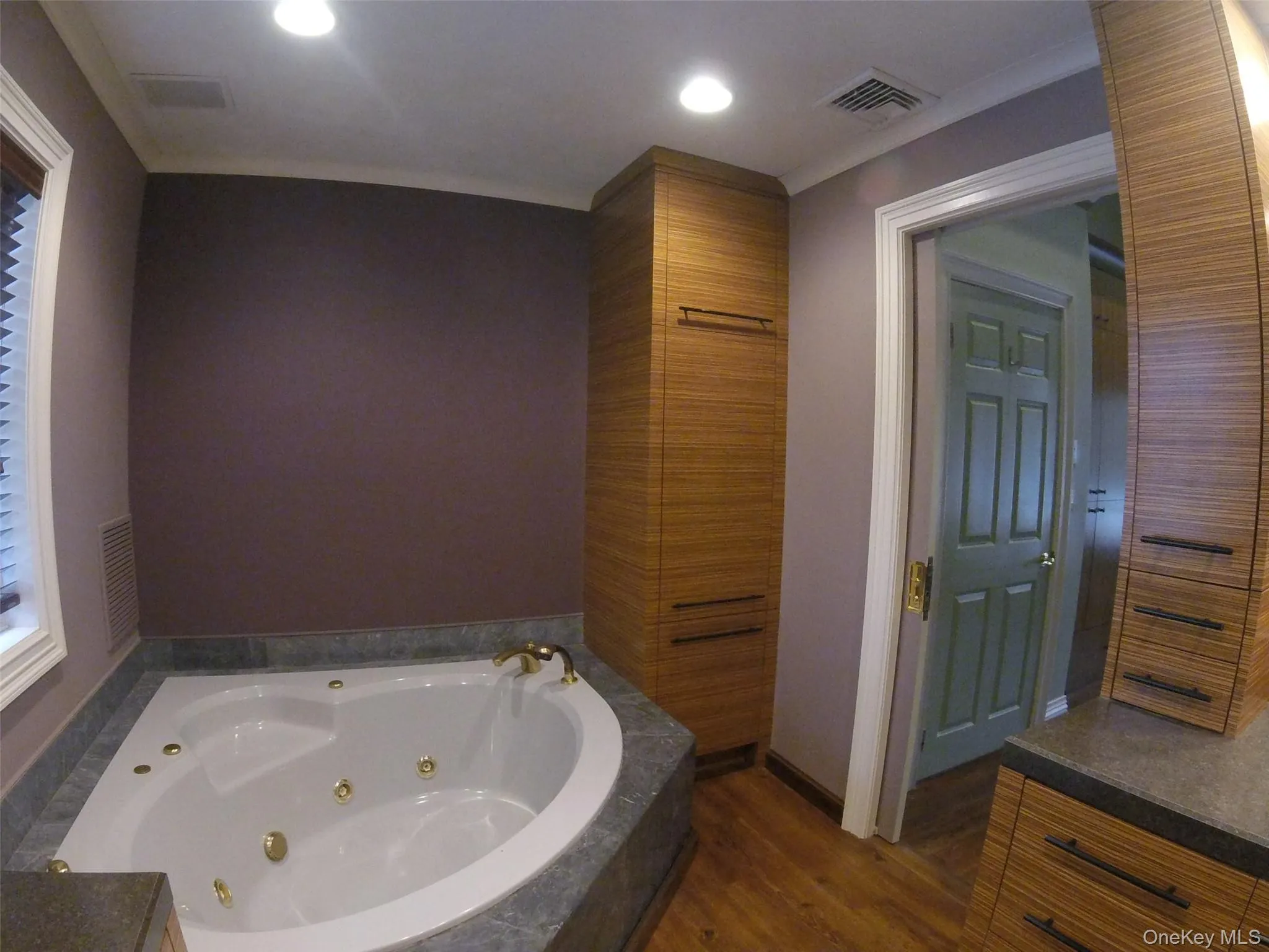 Soaking tub with a dark stone surround and gold-tone fixtures Soaking tub with a dark stone surround and gold-tone fixtures