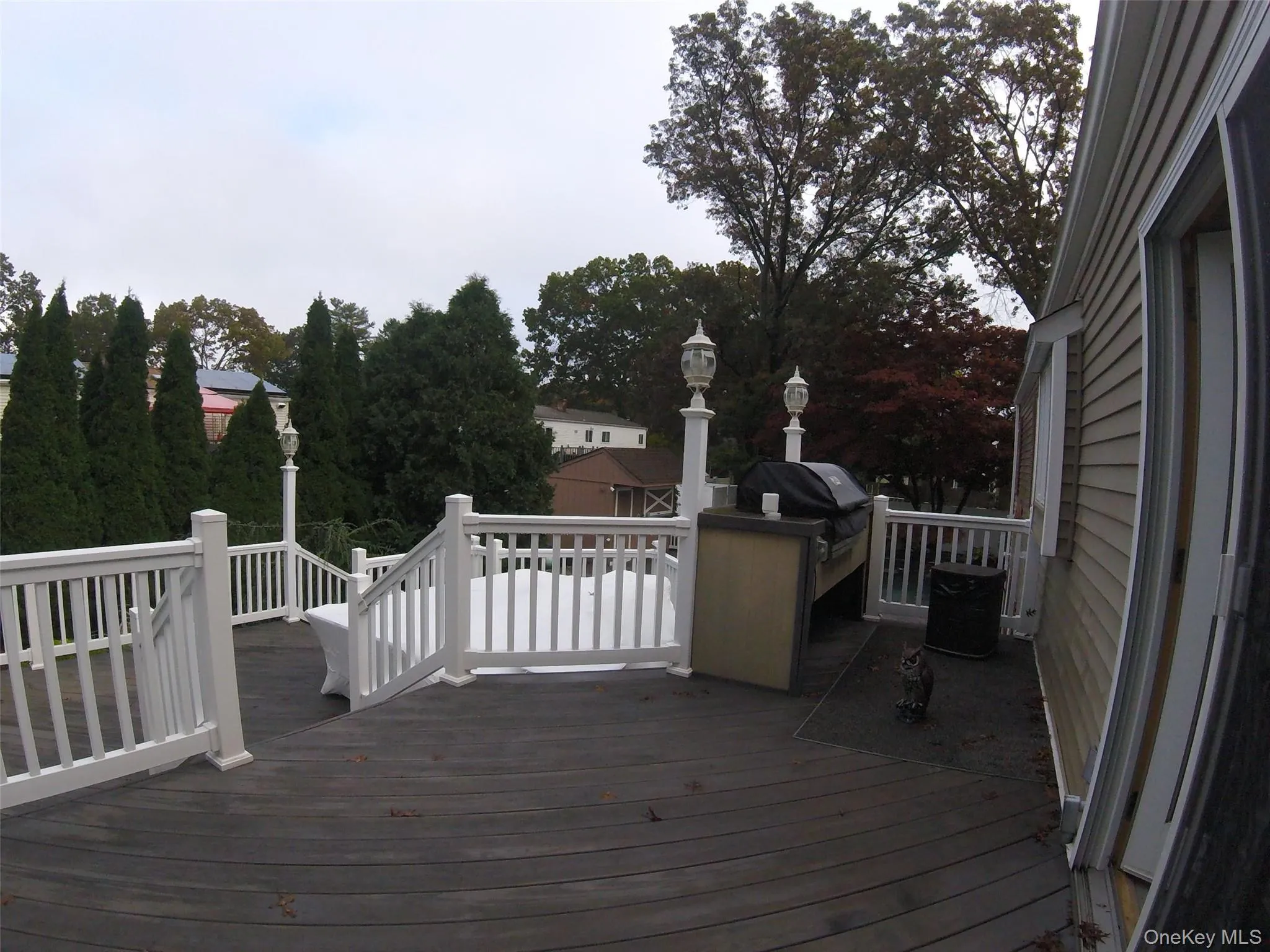 Expansive outdoor deck featuring dark wood-finish decking and white railing system Expansive outdoor deck featuring dark wood-finish decking and white railing system