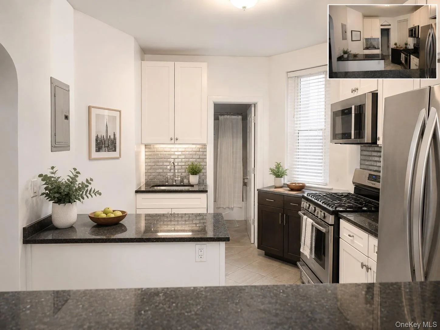 Contemporary kitchen featuring black granite countertops, white cabinetry, and stainless steel appliances (virtually staged) Contemporary kitchen featuring black granite countertops, white cabinetry, and stainless steel appliances (virtually staged)