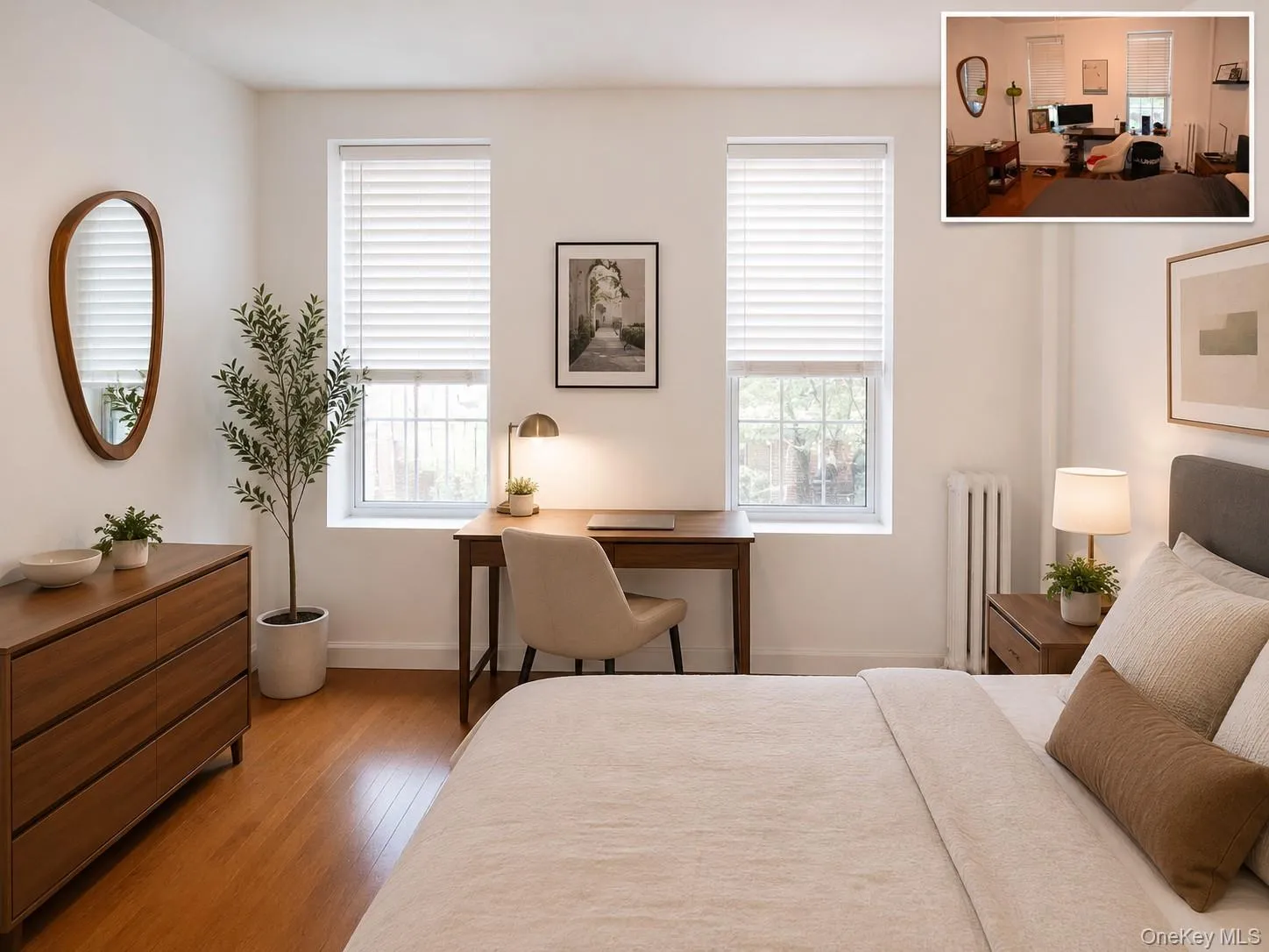 Room featuring two windows with white blinds, wood-finish flooring, and a built-in radiator (virtually staged) Room featuring two windows with white blinds, wood-finish flooring, and a built-in radiator (virtually staged)