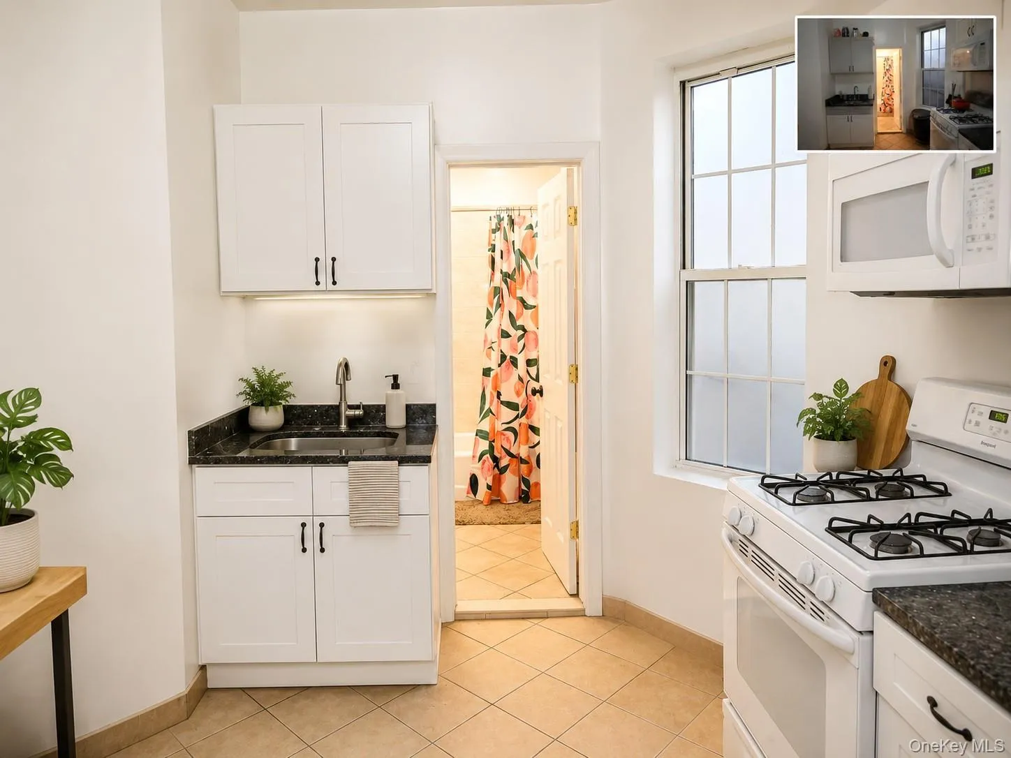 Kitchenette featuring white cabinetry, dark granite-finish countertops, and a stainless steel sink with a gooseneck faucet. (virtually staged) Kitchenette featuring white cabinetry, dark granite-finish countertops, and a stainless steel sink with a gooseneck faucet. (virtually staged)