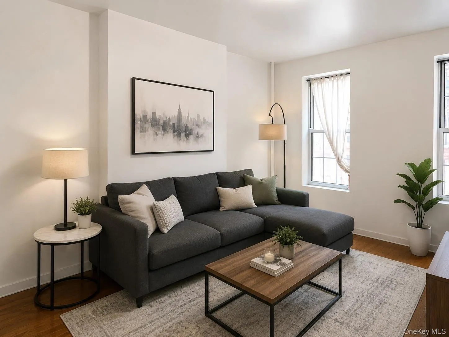 Living area with abundant natural light, featuring wood-finish flooring and crisp white walls (virtually staged) Living area with abundant natural light, featuring wood-finish flooring and crisp white walls (virtually staged)