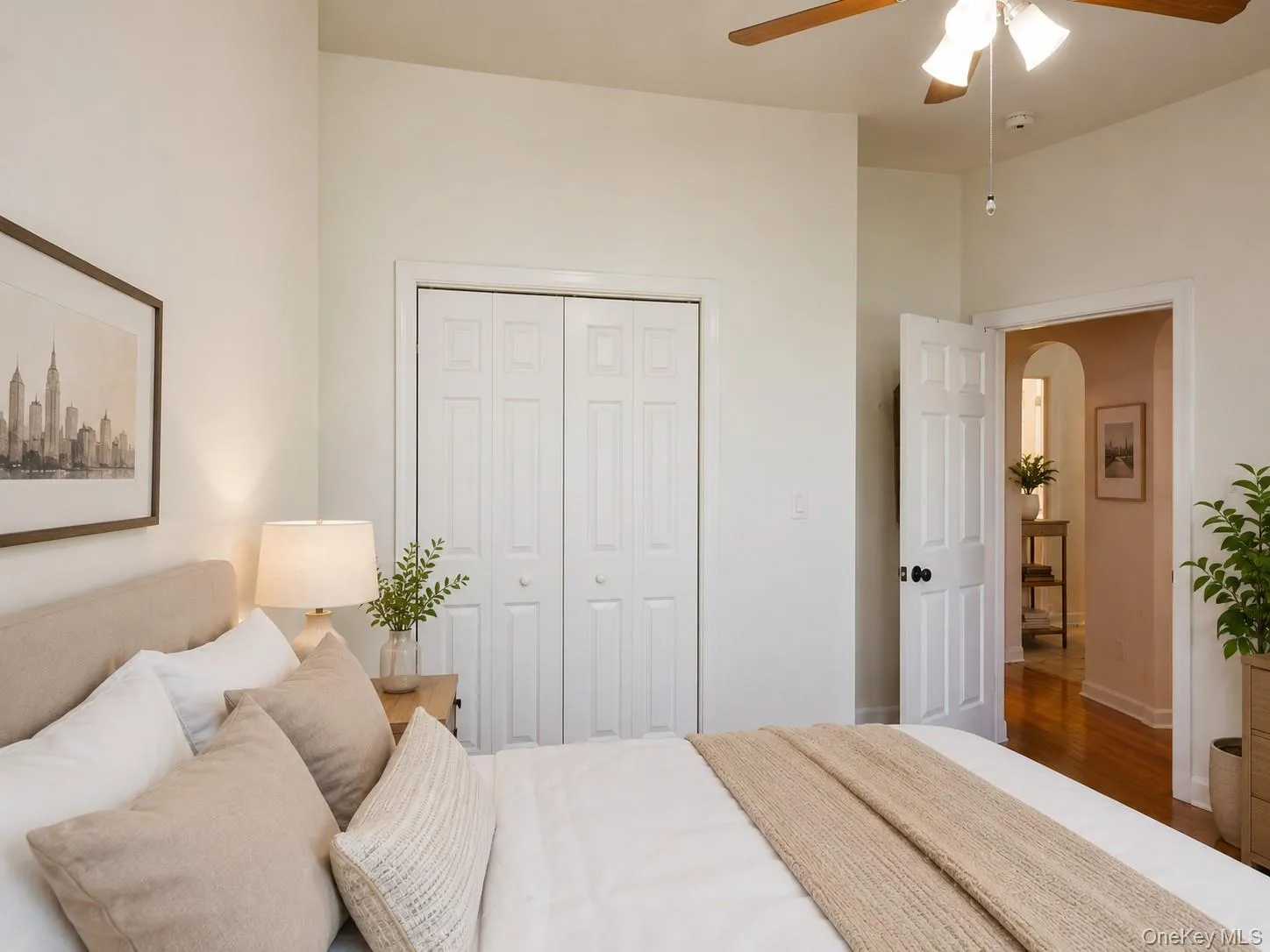 Bedroom featuring a ceiling fan with integrated lighting, wood-finish flooring, and white bi-fold closet doors (virtually staged) Bedroom featuring a ceiling fan with integrated lighting, wood-finish flooring, and white bi-fold closet doors (virtually staged)