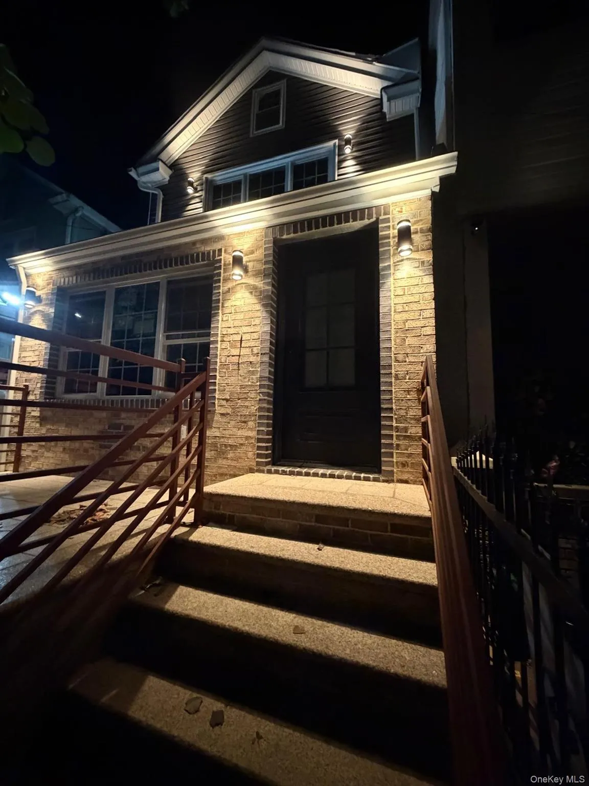 Brick and siding facade with transom windows and multiple exterior wall sconces Brick and siding facade with transom windows and multiple exterior wall sconces