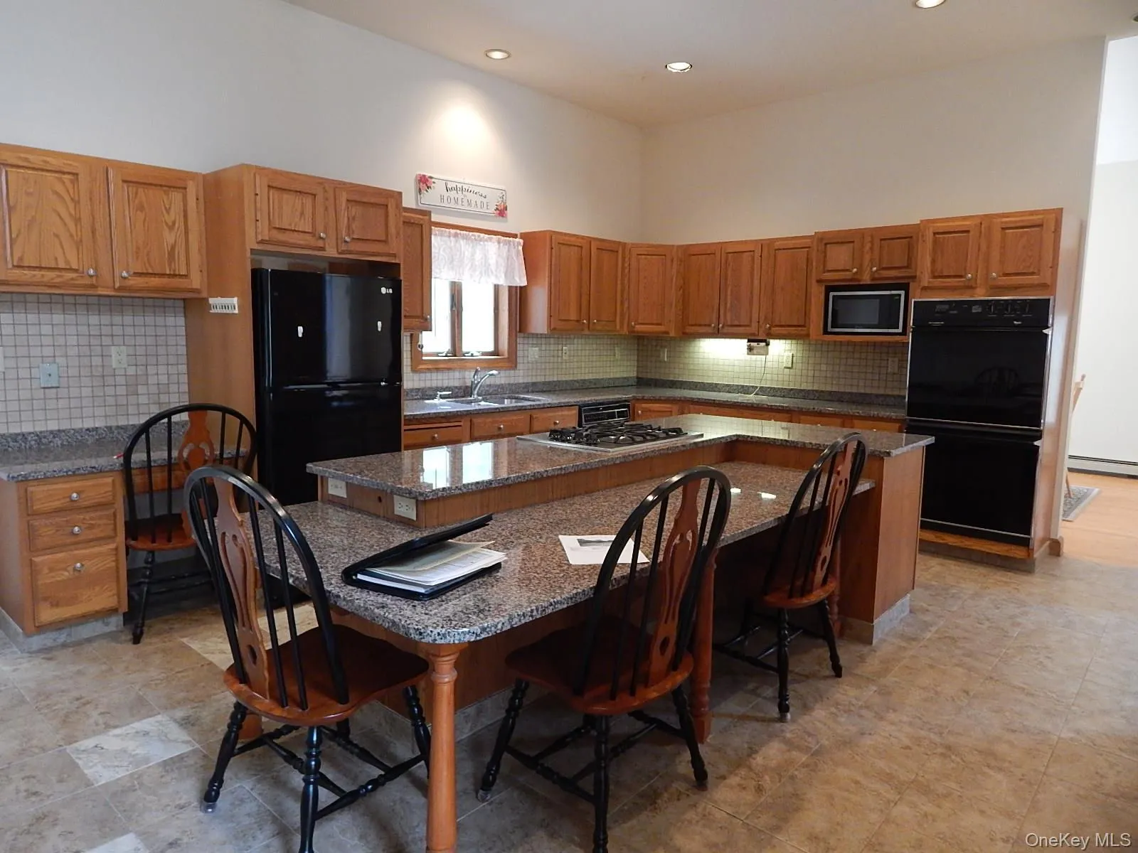 Island kitchen with granite countertops, oak cabinets, ceramic tile floor and backsplash, recessed lighting, breakfast area, built-in cooktop, double oven, desk, and built-in microwave oven, pantry and closeted laundry (not shown) Island kitchen with granite countertops, oak cabinets, ceramic tile floor and backsplash, recessed lighting, breakfast area, built-in cooktop, double oven, desk, and built-in microwave oven, pantry and closeted laundry (not shown)