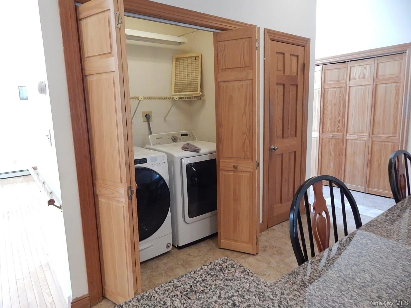Closeted laundry with raised panel wood doors. Closeted laundry with raised panel wood doors.